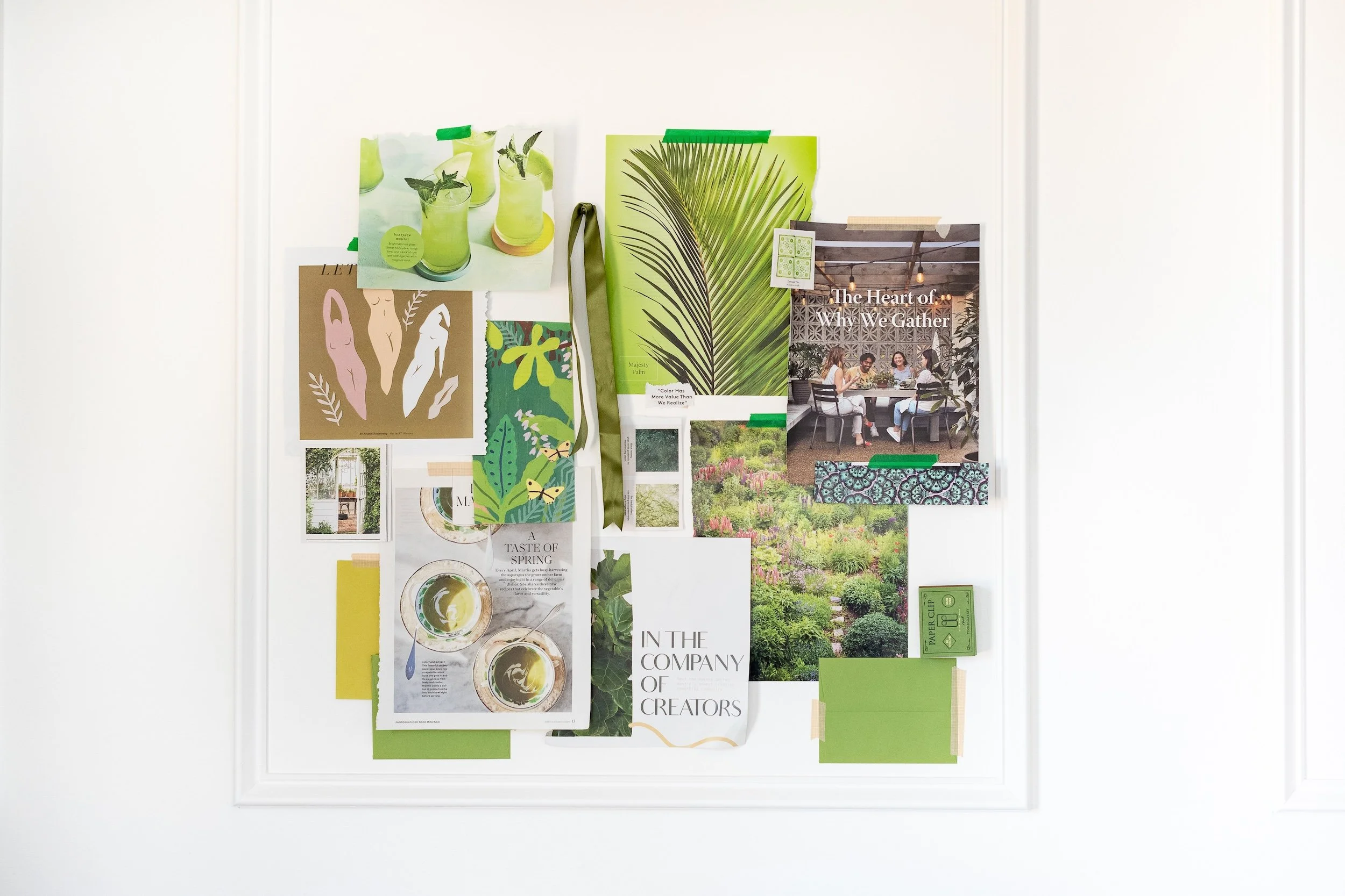 A white framed bulletin board with various green-themed photos, magazine clippings, and images pinned with green and beige tapes, including plants, drinks, people gathering, and nature scenes.