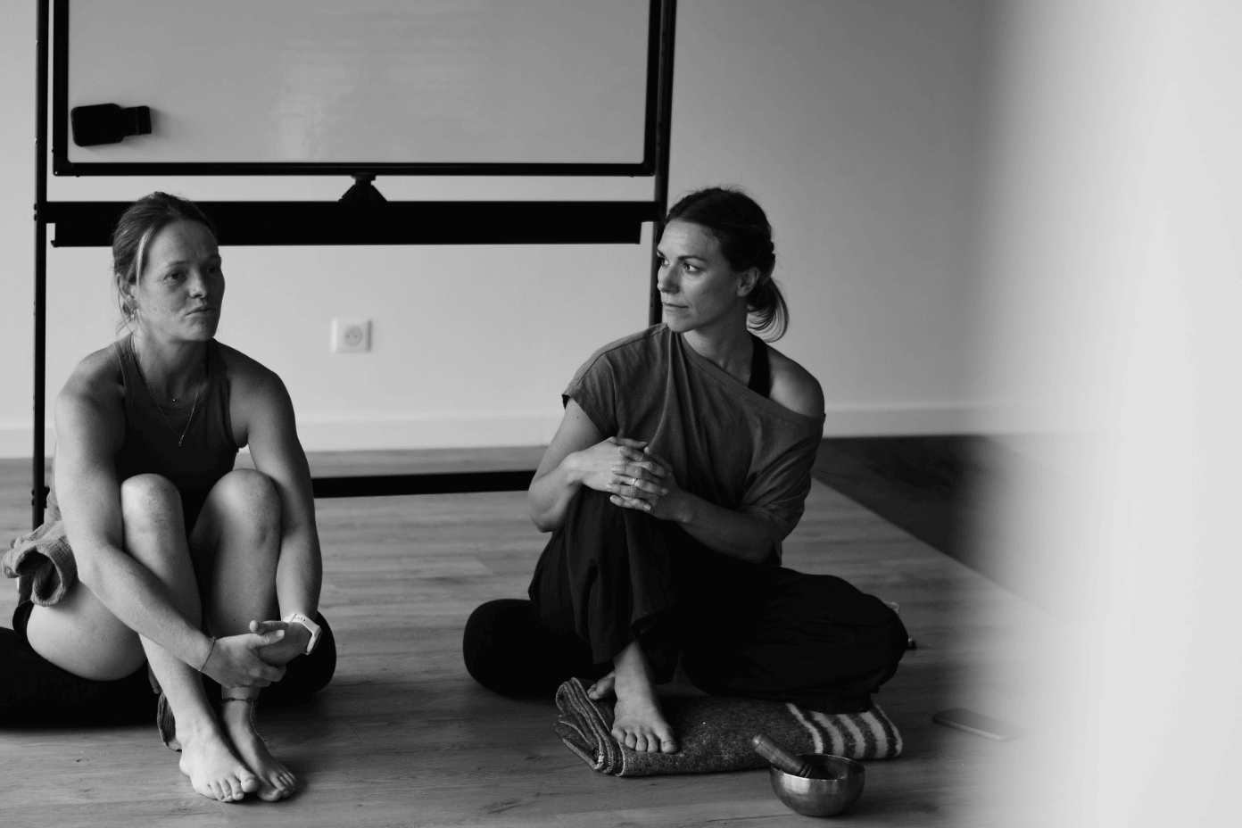enseignantes de yoga assises au sol devant un tableau blanc