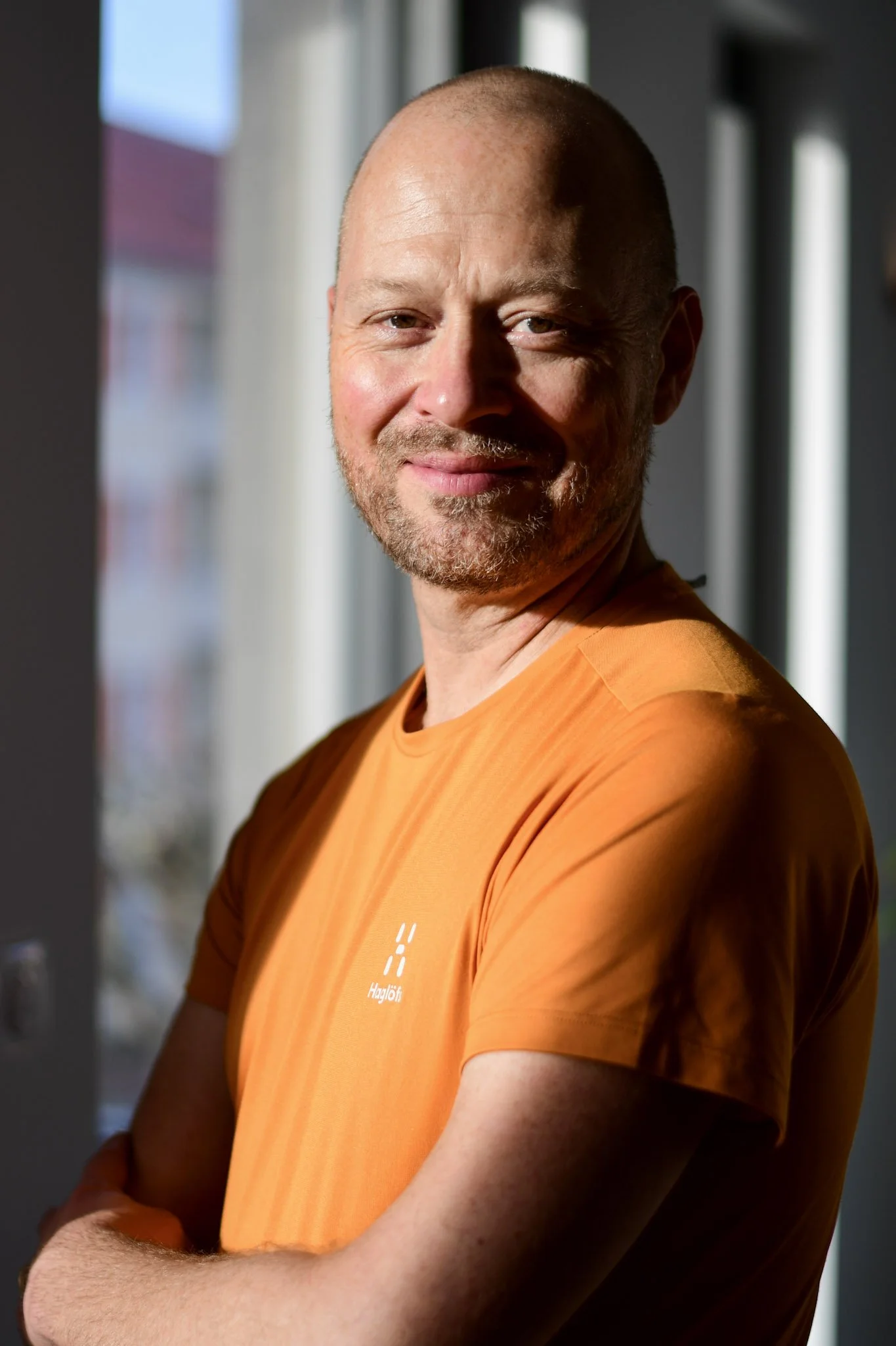 Portrait d'un homme chauve avec un t-shirt orange