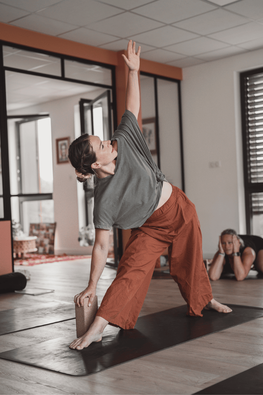 professeur de yoga en trikonasana