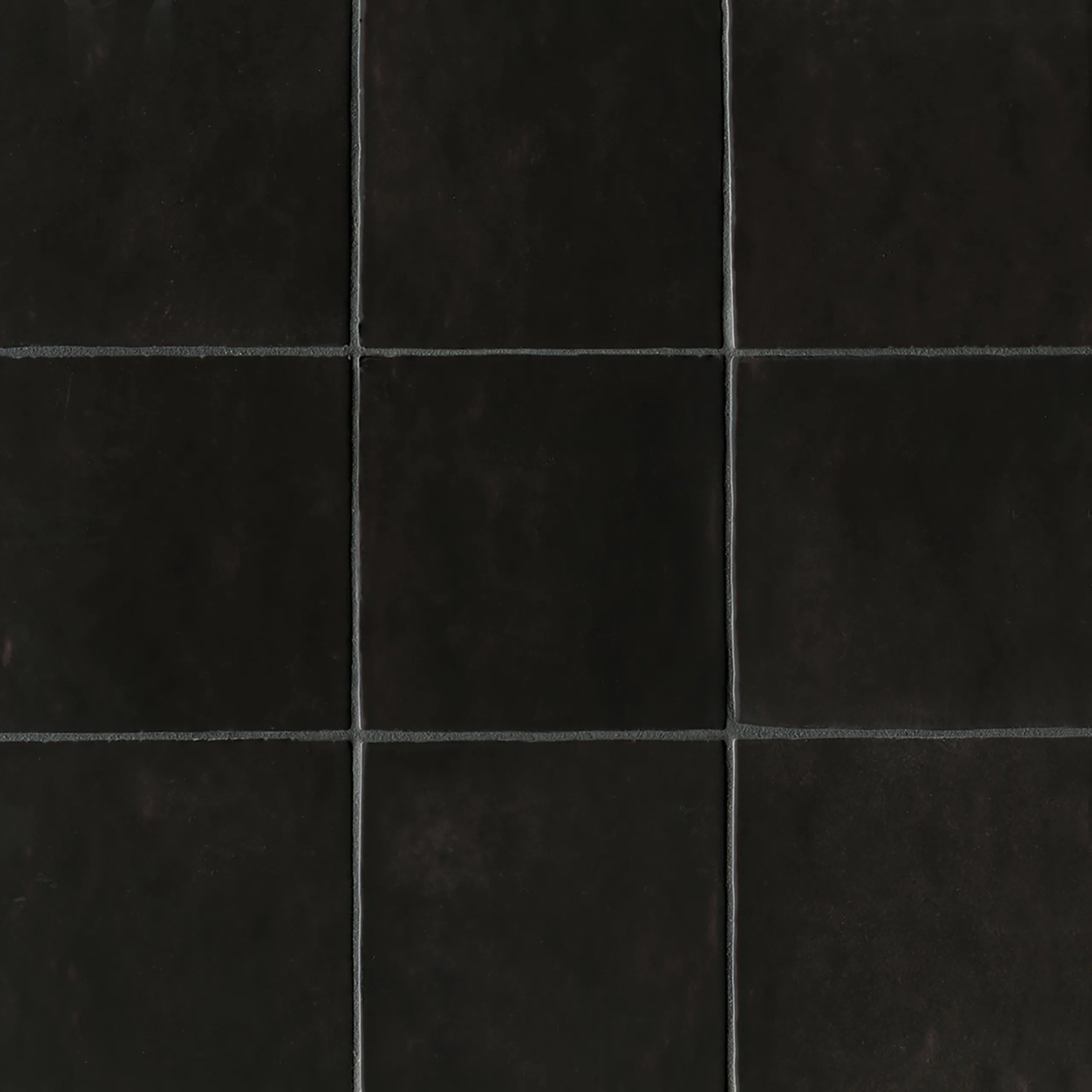 Close-up of black tiles with gray grout lines.