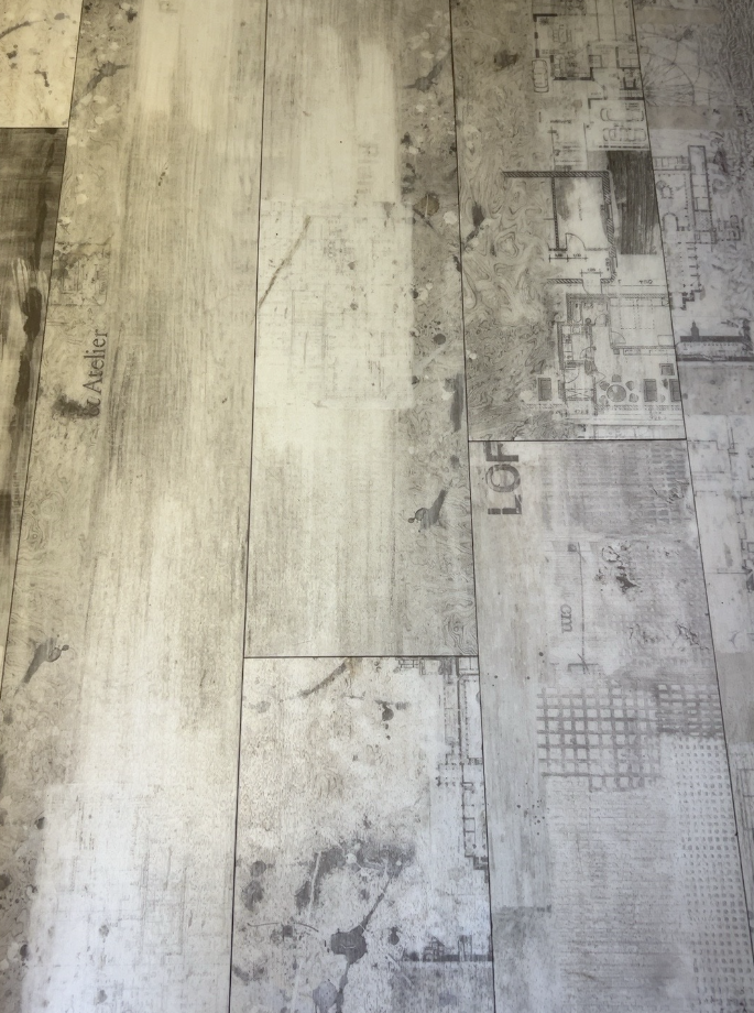 Milliken Eero luxury vinyl planks with decorative grey pattern, actual stock
