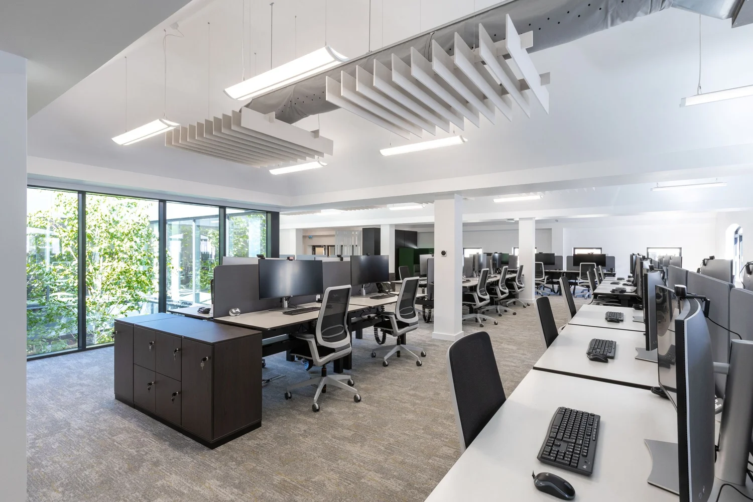 Workstations with acoustic ceiling baffles and desk screens at FNB.