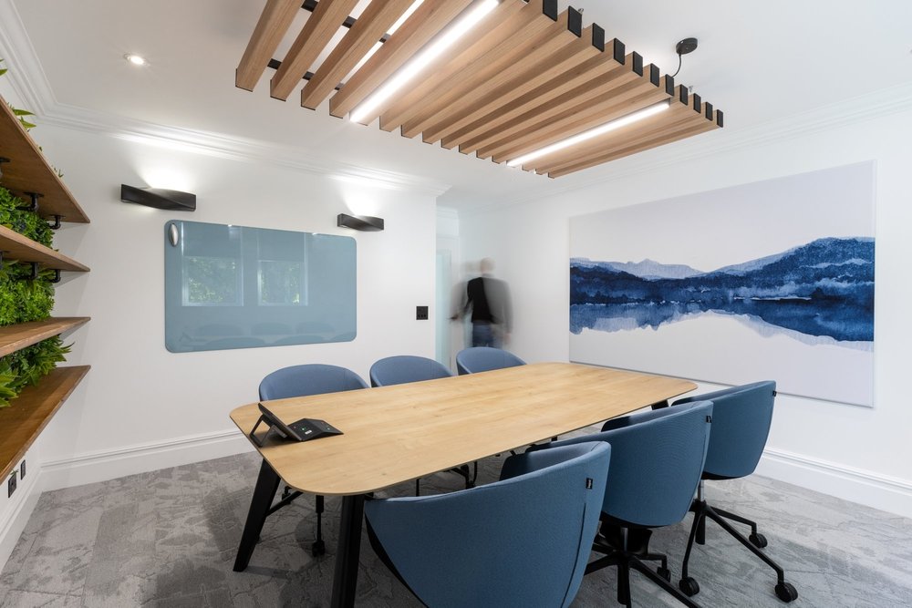Healthspan six-person meeting room with acoustic ceiling beams, screen and printed wall panel
