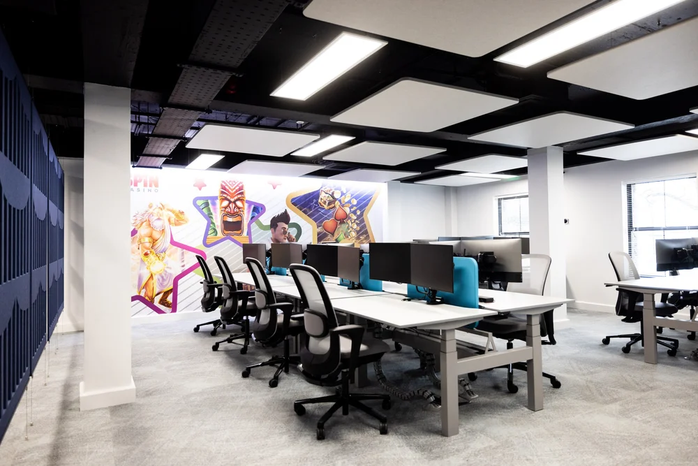 Workstations beneath suspended acoustic panels