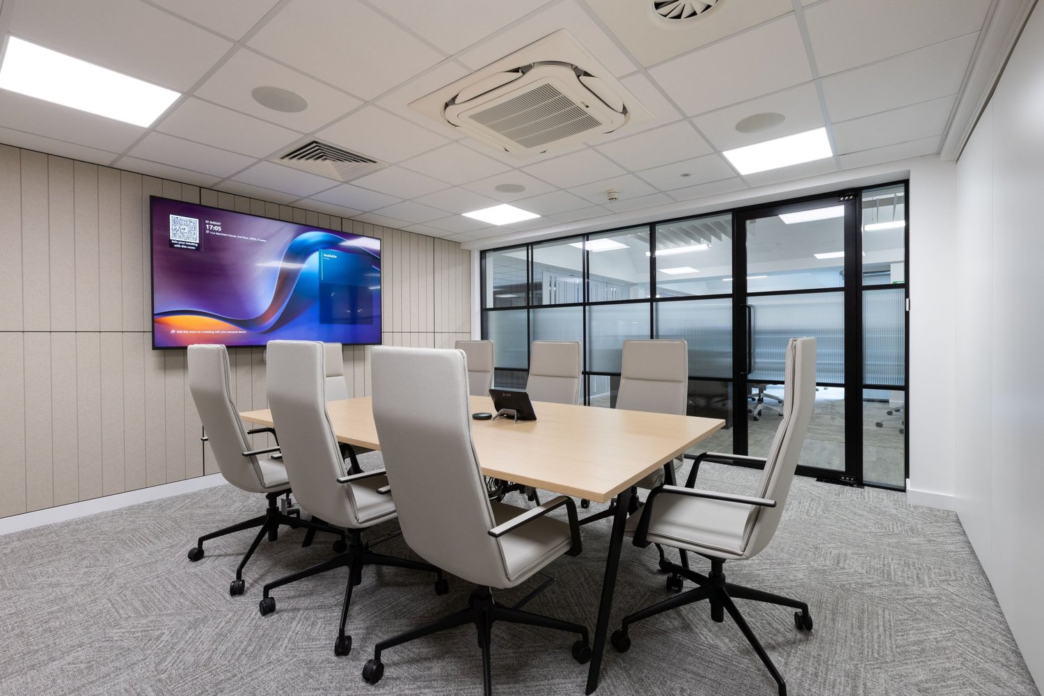 Completed FNB meeting room with integrated screen, acoustic finishes and glazed partitions.