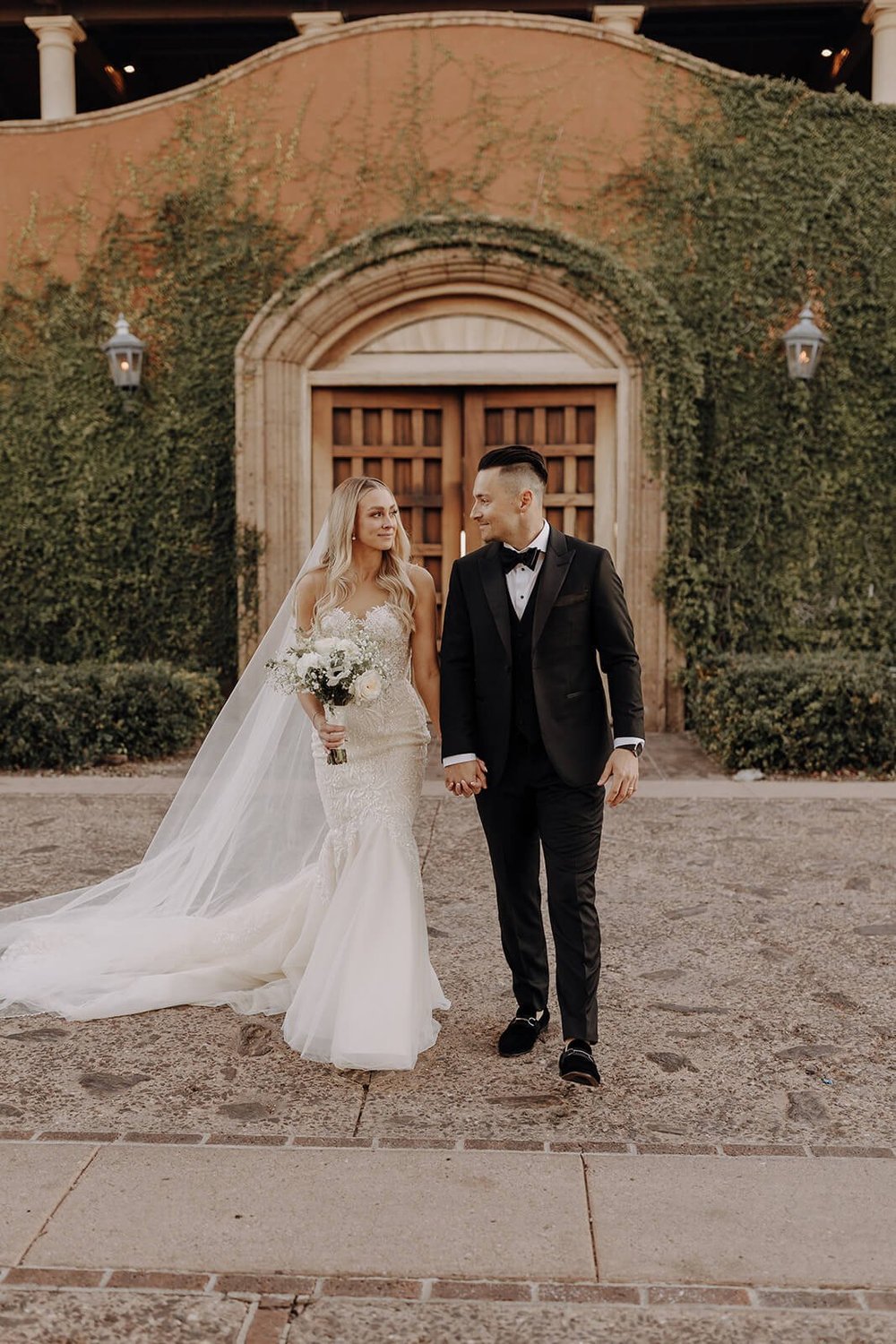 Bride and groom walking in Blackstone Country Club courtyard