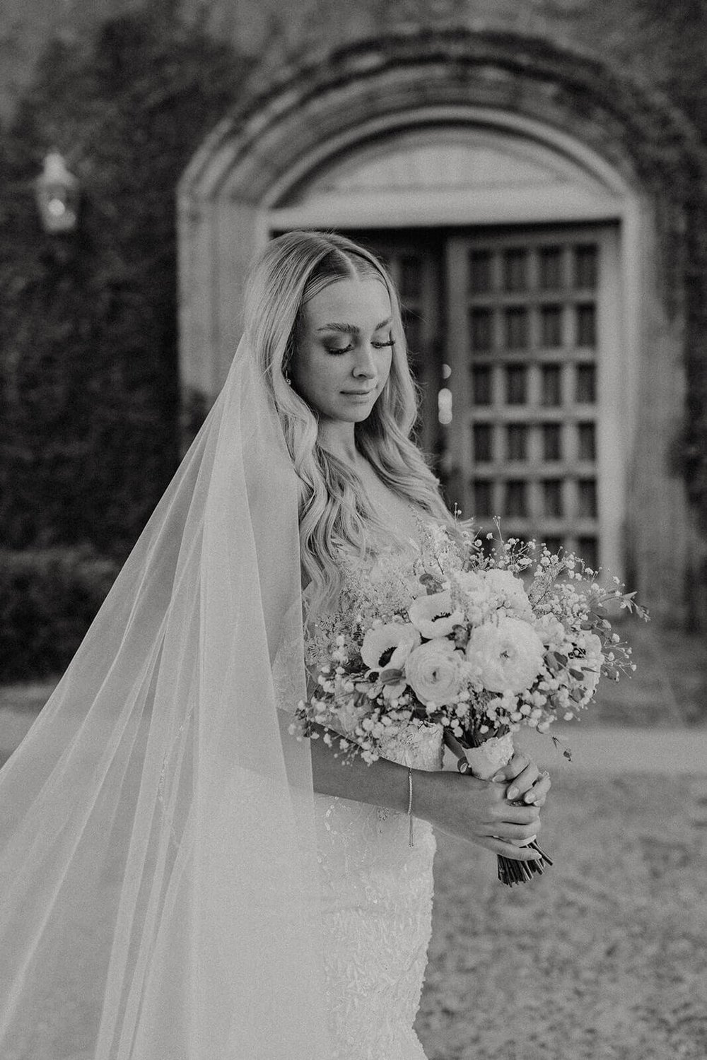 Black and white photo of bride standing in front of Blackstone Country Club in Arizona