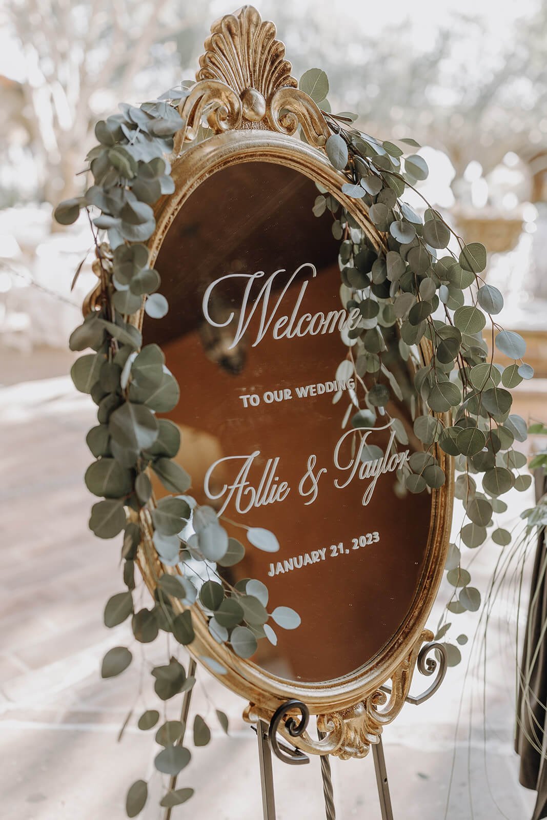 Ornate gold reception welcome sign with eucalyptus 