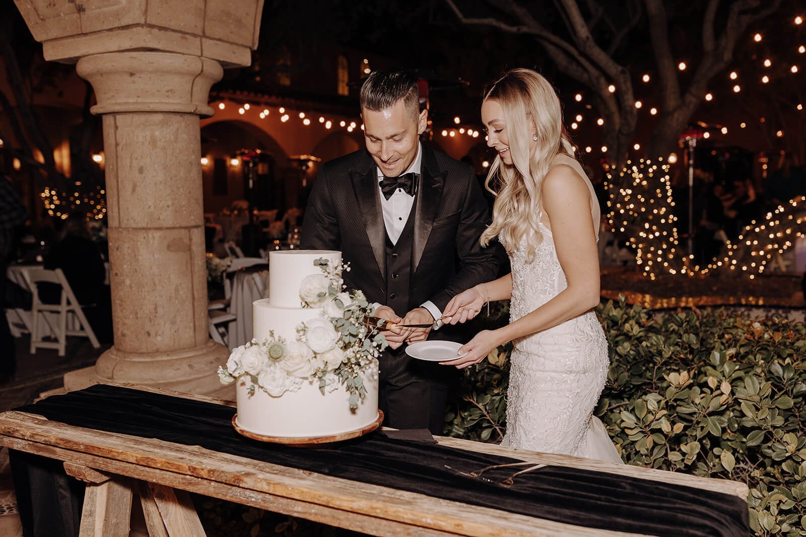 Bride and groom cutting wedding cake at classy black and white wedding in Arizona