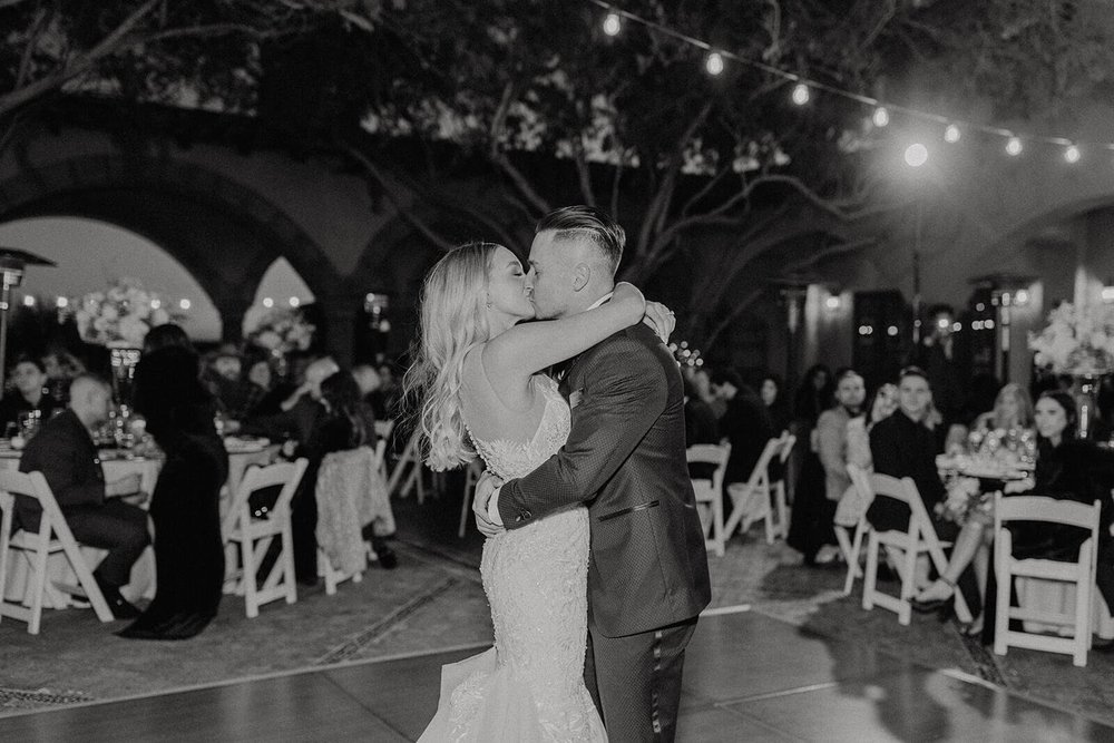 Black and white photo of bride and groom dancing in courtyard at Blackstone Country Club wedding