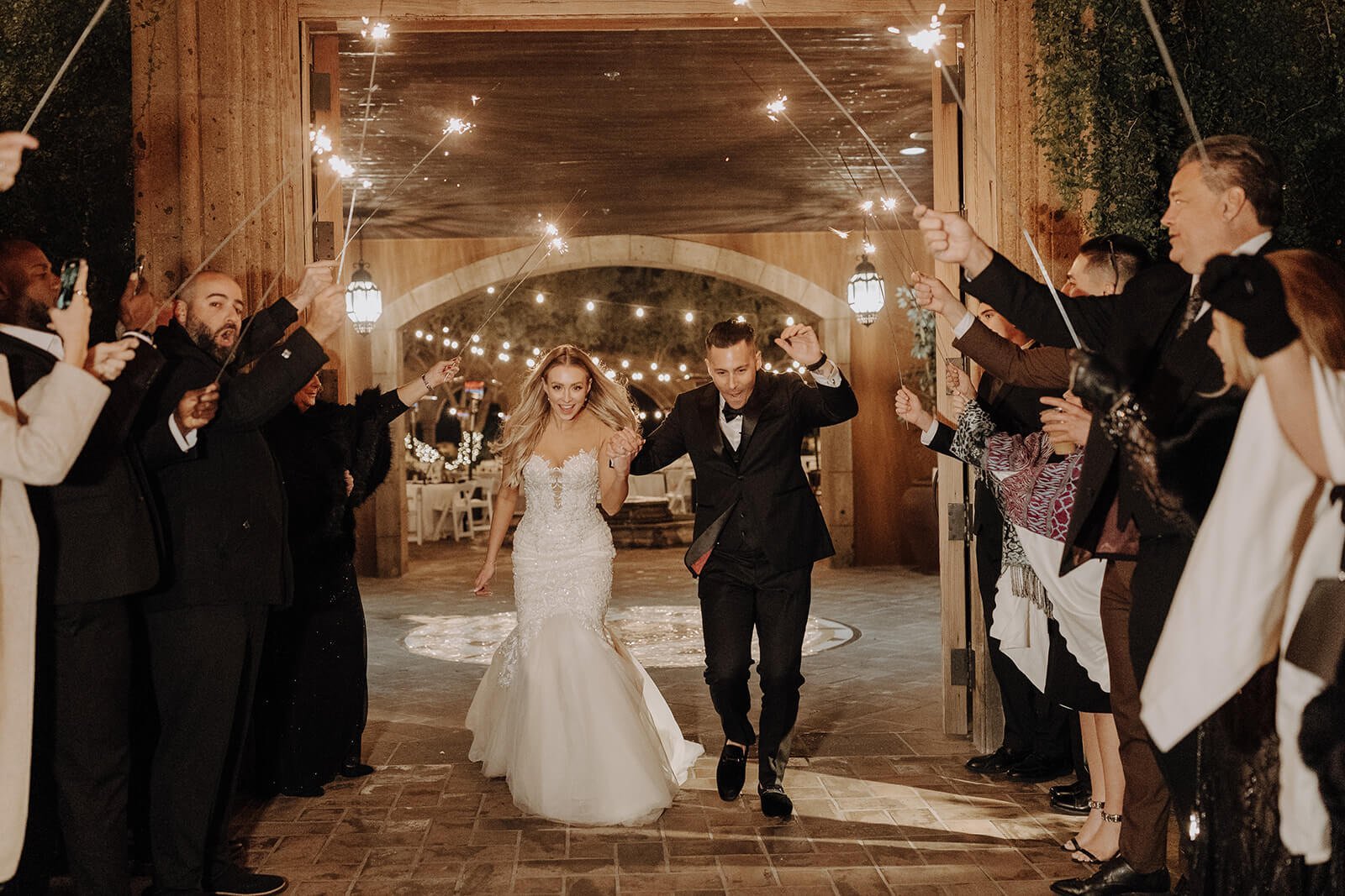 Bride and groom sendoff through aisle of sparklers in courtyard of Blackstone Country Club