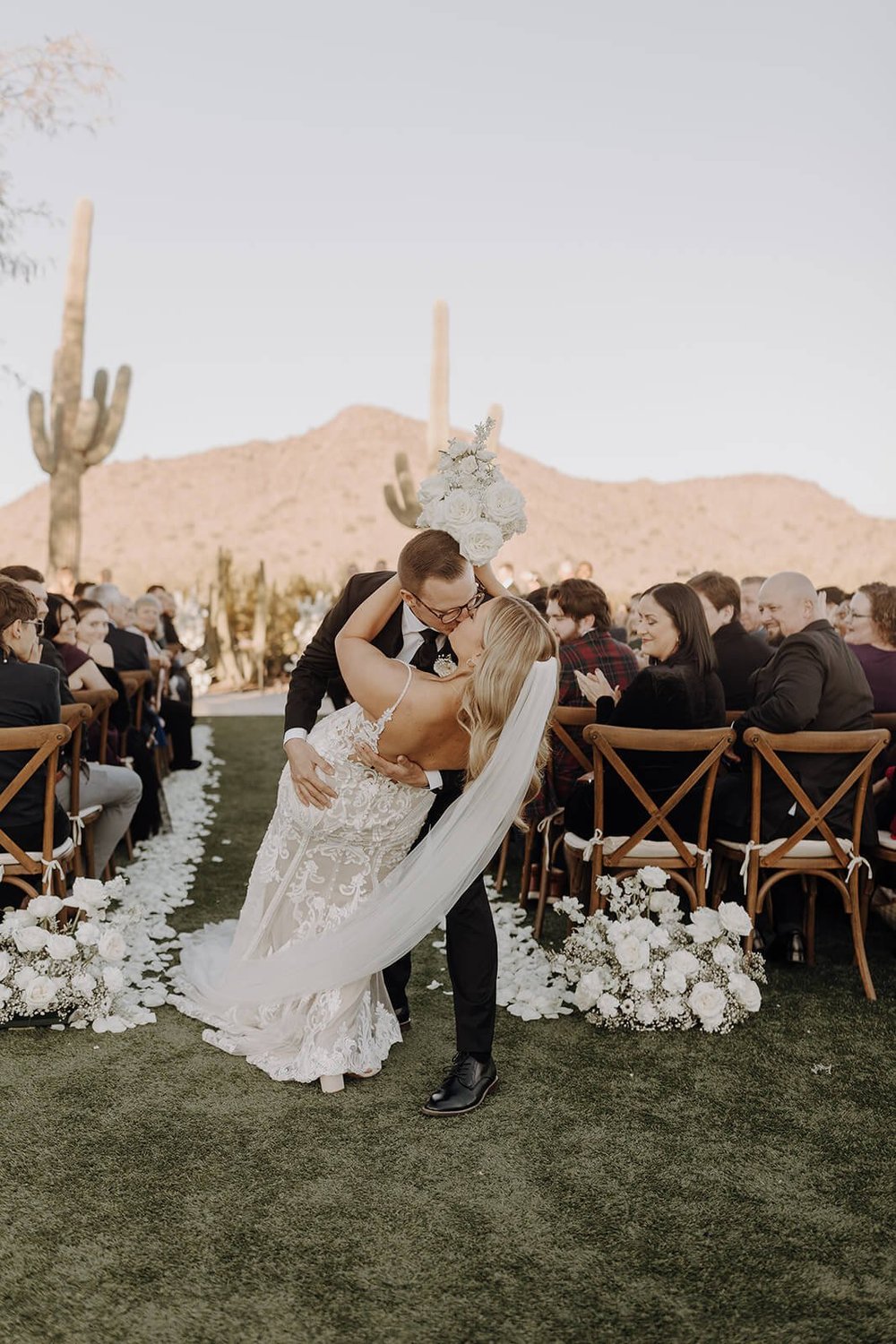 Groom dips bride for a kiss at end of ceremony at Arizona destination wedding