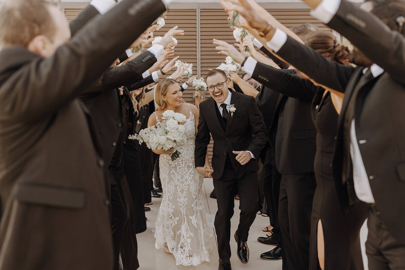 Bride and groom walk through tunnel of bridal party