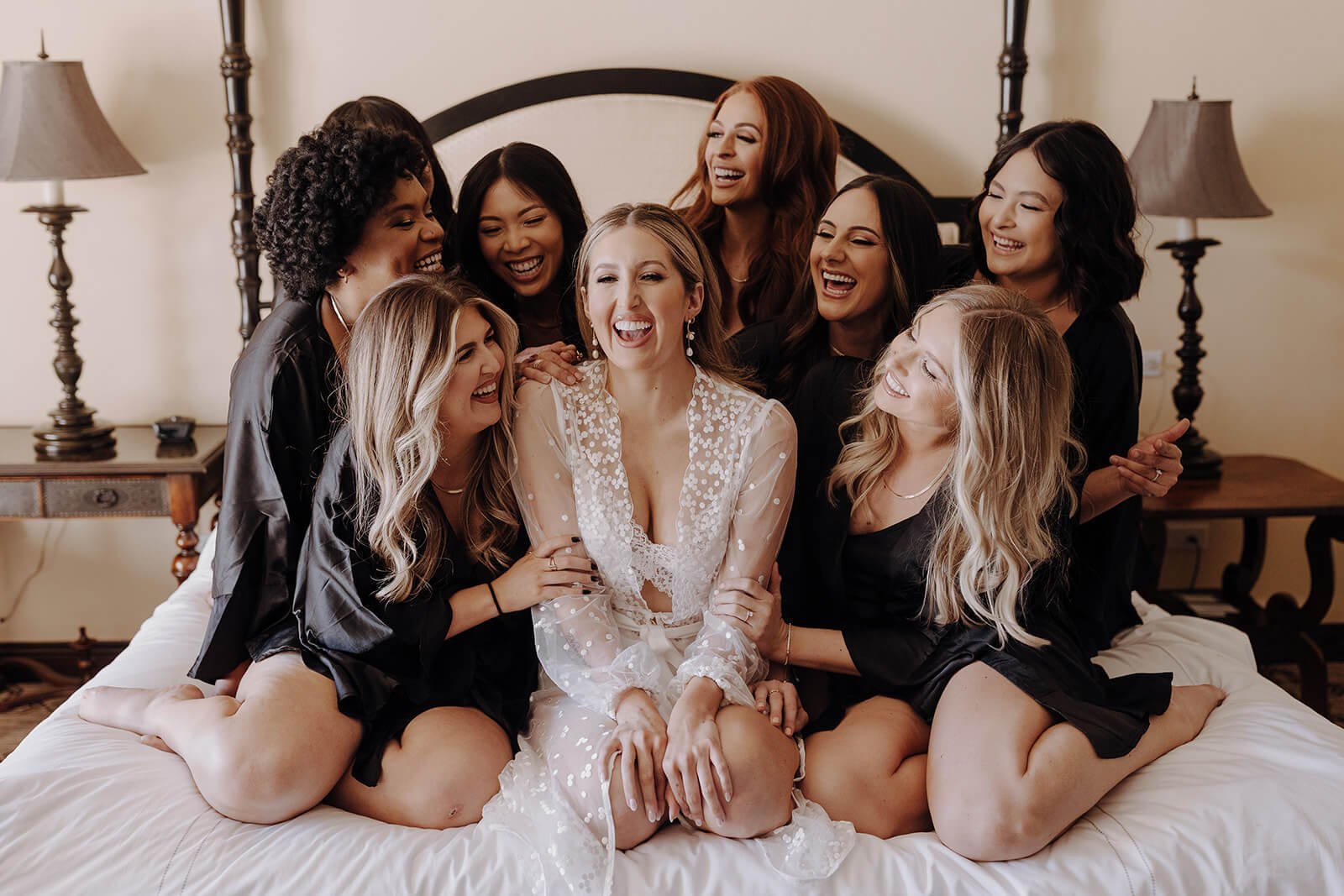 Bridesmaids on bed in silk robes before luxury Scottsdale wedding
