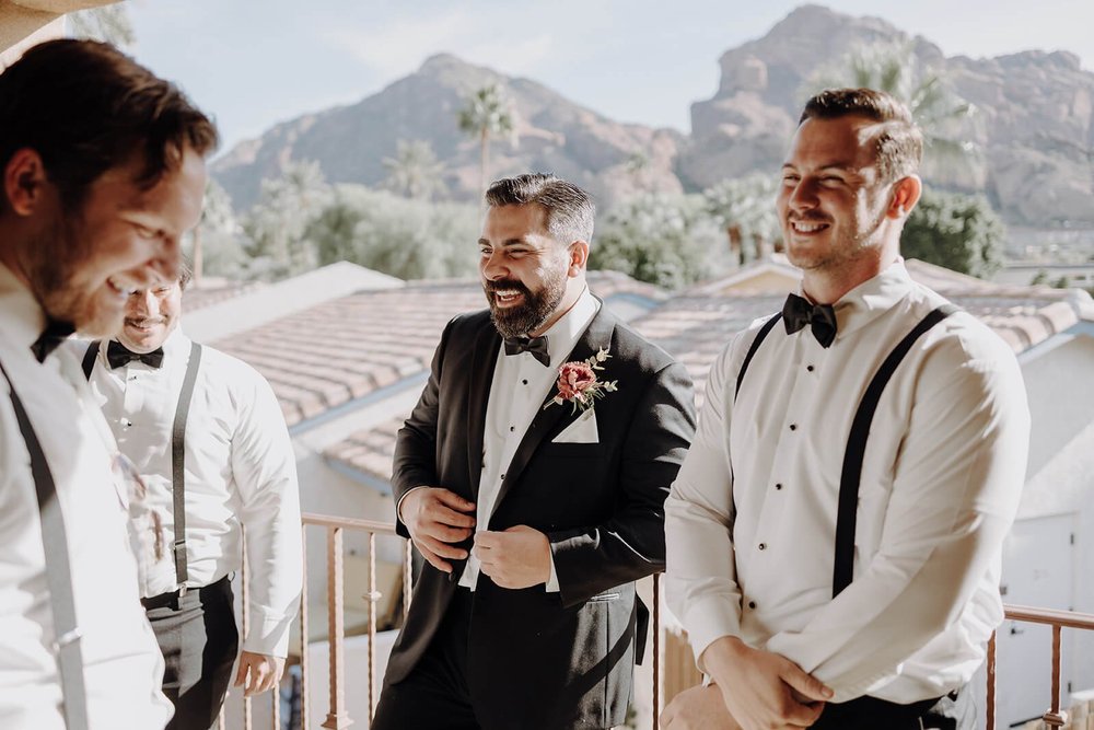 Groom and groomsmen getting ready with mountains in background for luxury Scottsdale wedding
