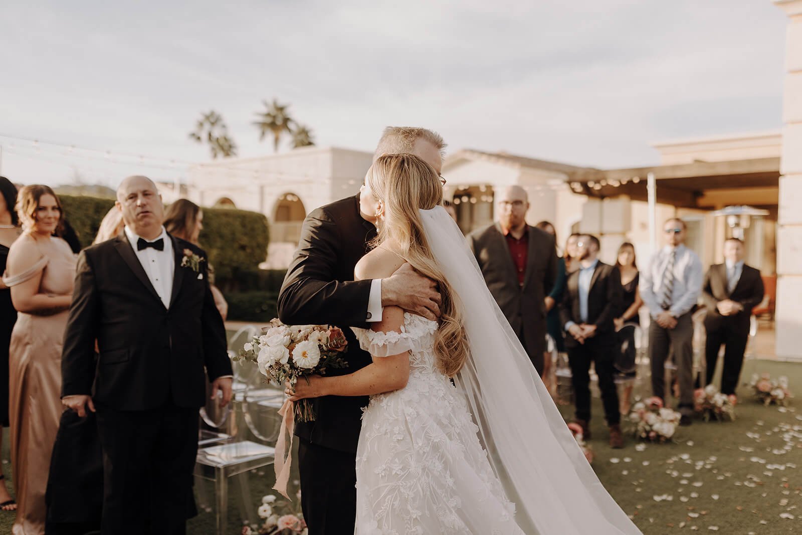 Father of the bride hugs bride at luxury Scottsdale wedding