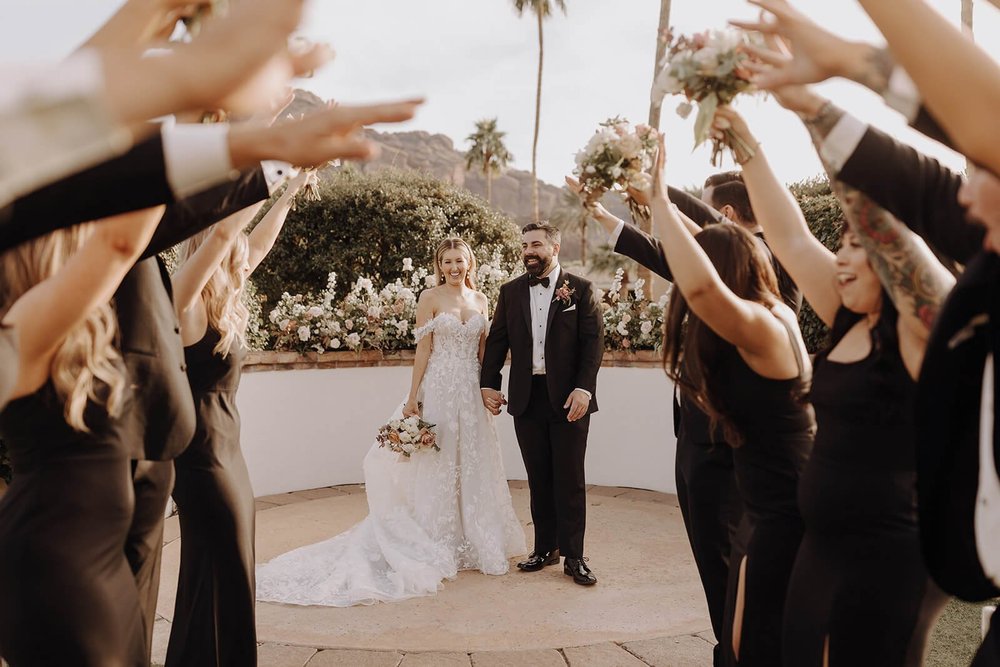 Bride and groom walk through tunnel of bridal party