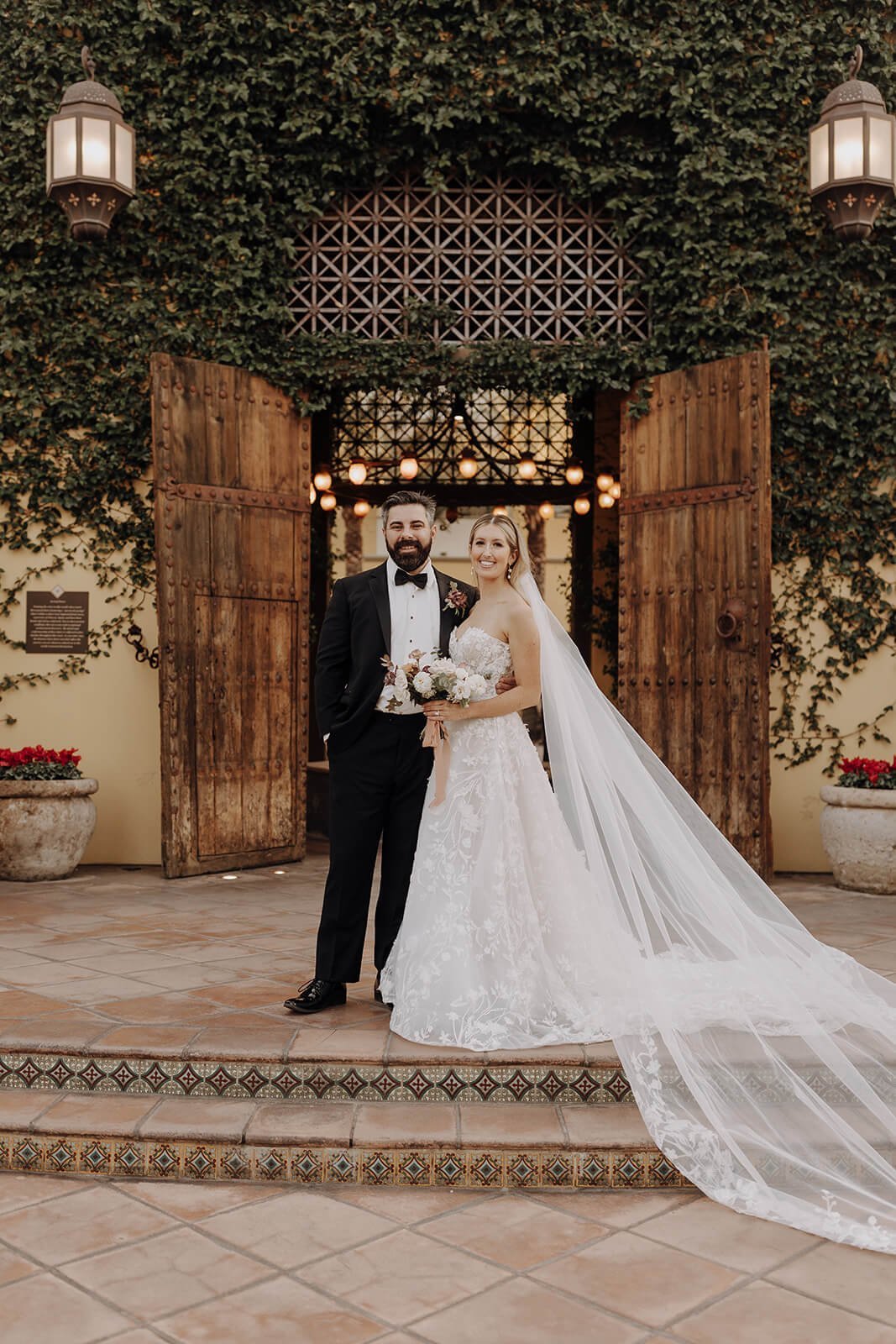 Bride and groom posing outside luxury Spanish style resort