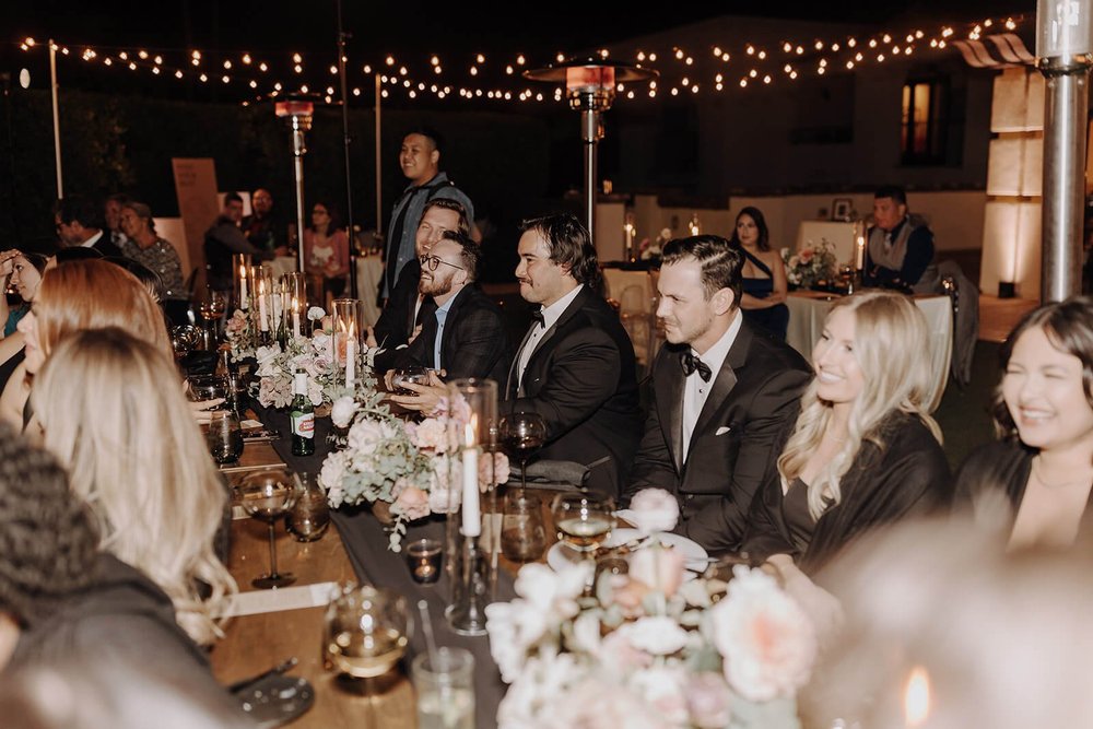 Wedding guests sitting at tables under lights outdoor at luxury Scottsdale wedding