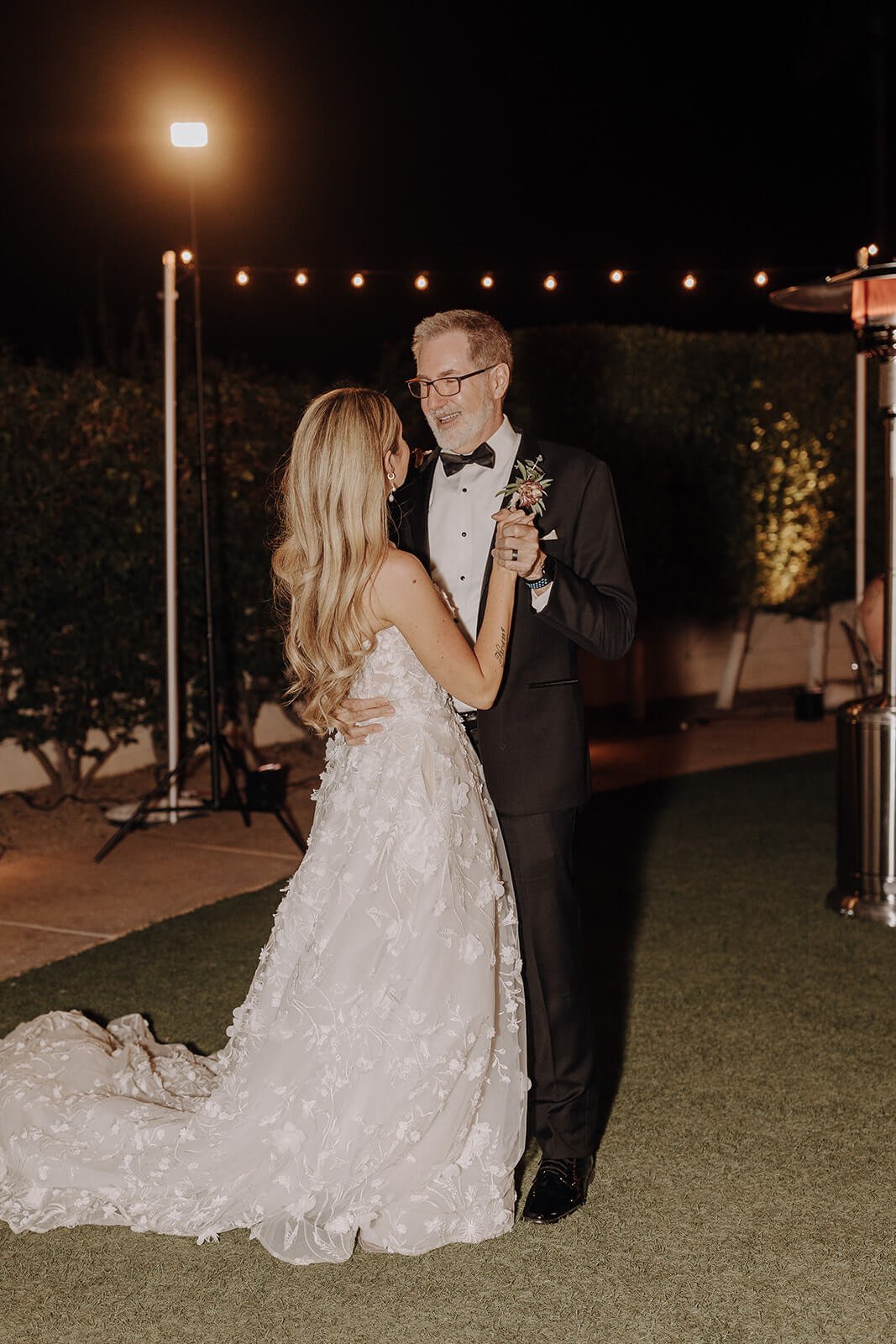 Bride and father dance under lights outdoors at luxury Scottsdale wedding