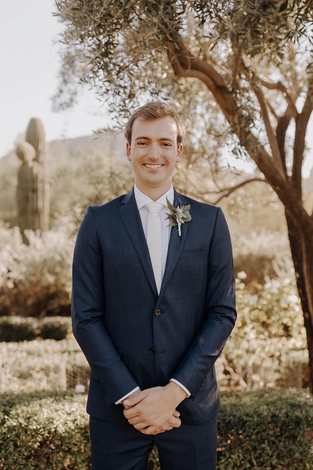 Desert wedding groom standing outside