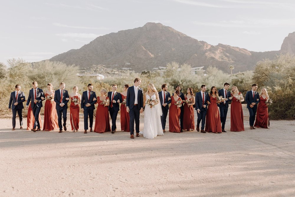 Arizona desert wedding bride and groom walking with bridesmaids and groomsmen, mountains in the background