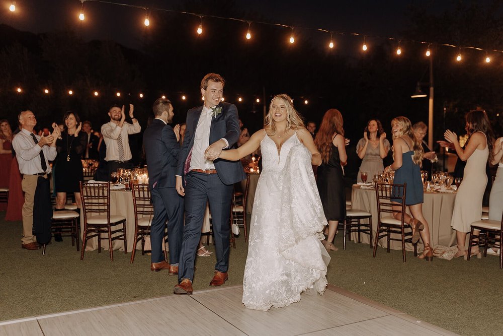 Bride and groom entering outdoor dance floor for their first dance