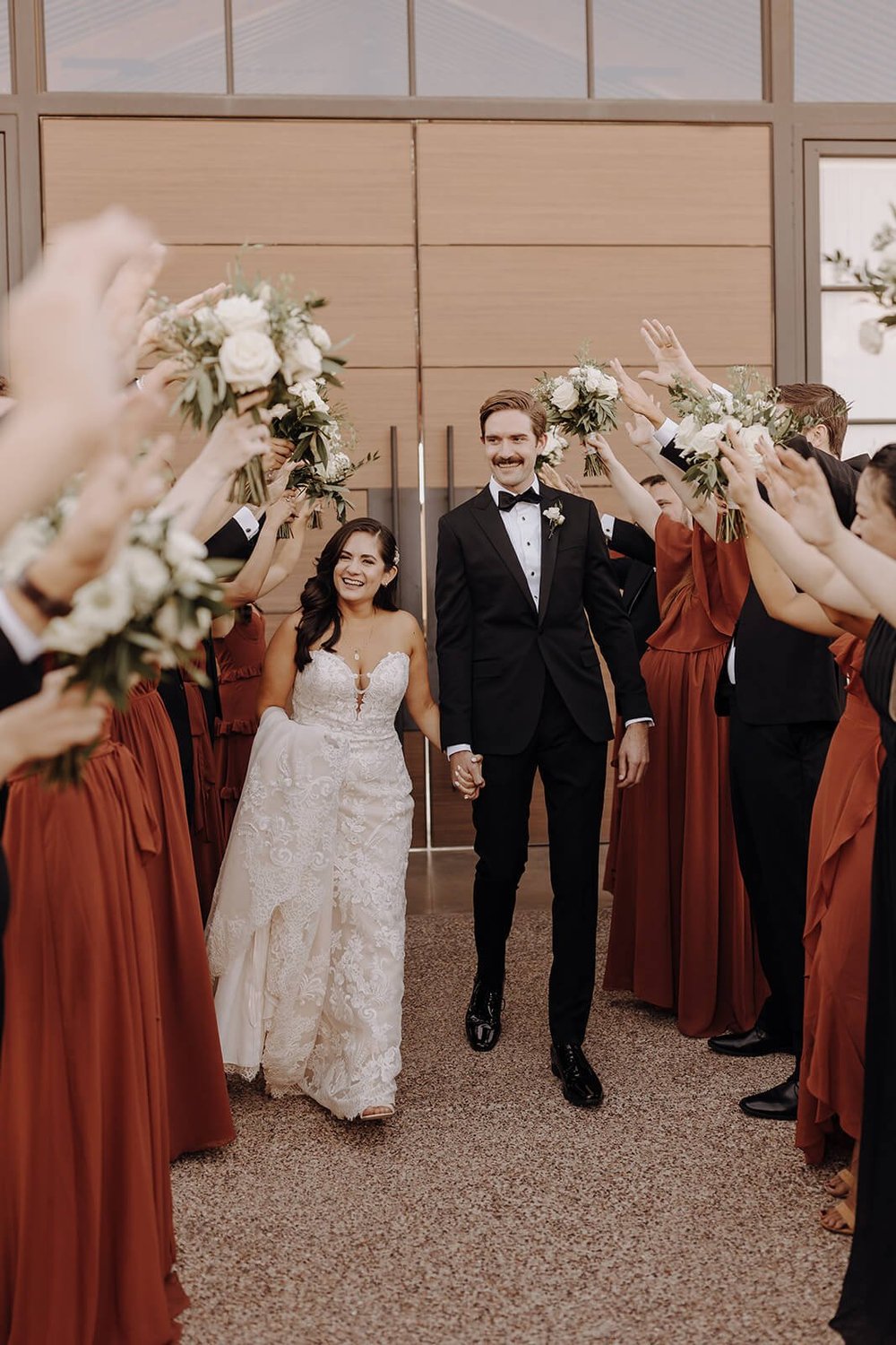 Bride and groom run through wedding party at The Paseo