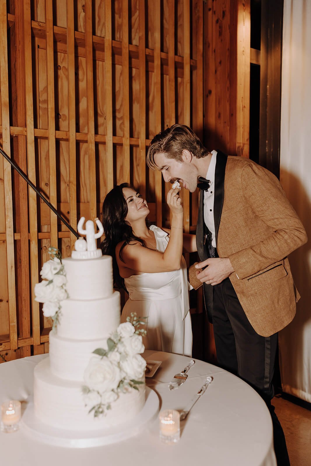 Bride and groom feed each other wedding cake at Arizona desert wedding