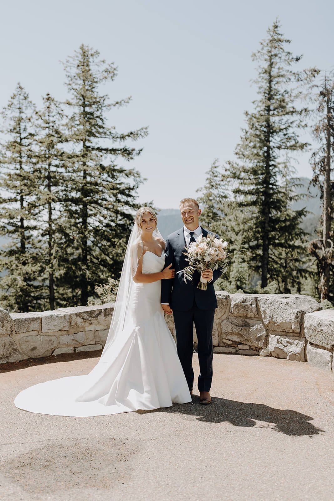 Bride wearing white Essense of Australia wedding dress posing with groom for Mount Rainier wedding portraits