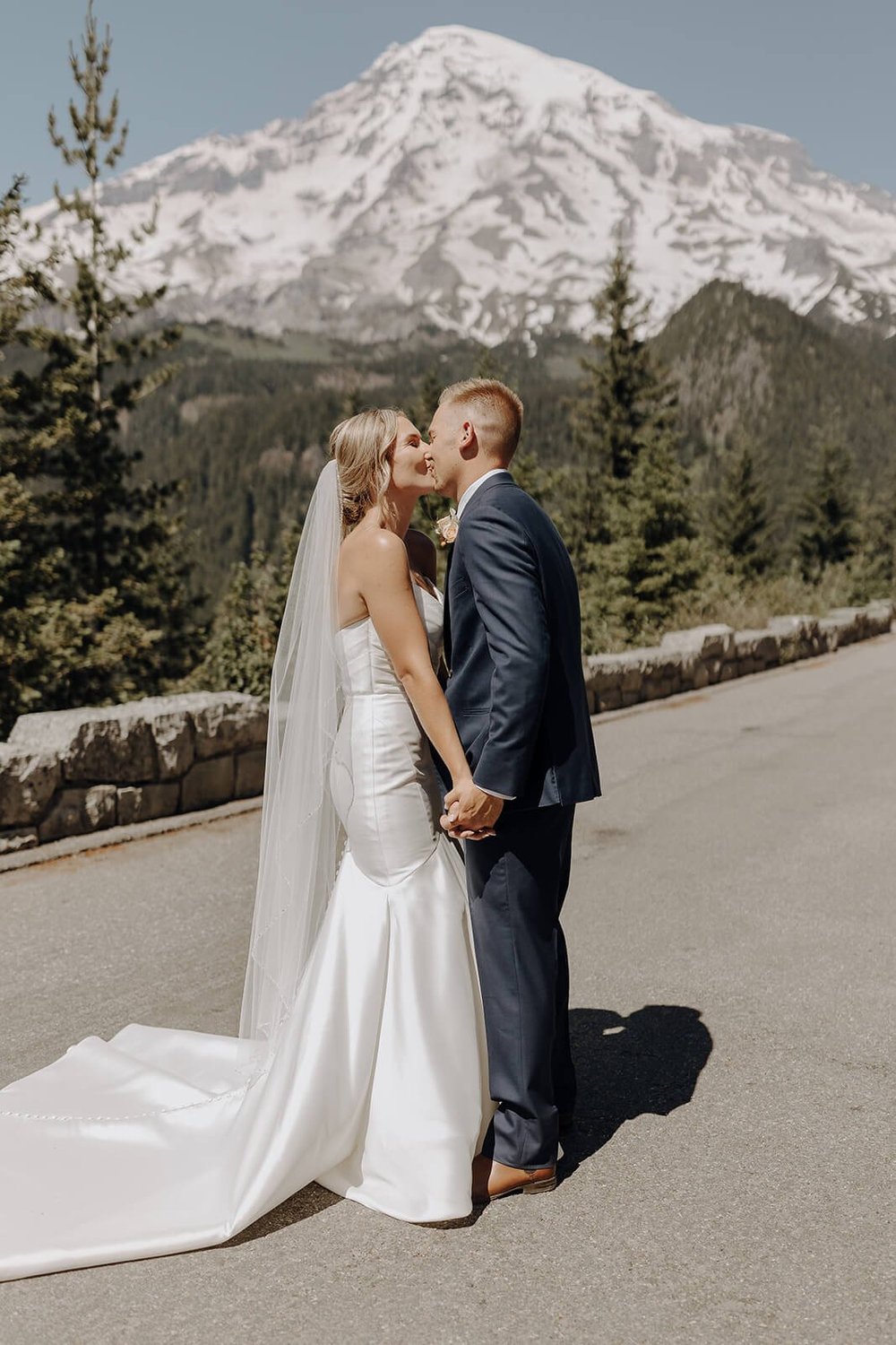 Bride and groom kiss in front of Mount Rainier