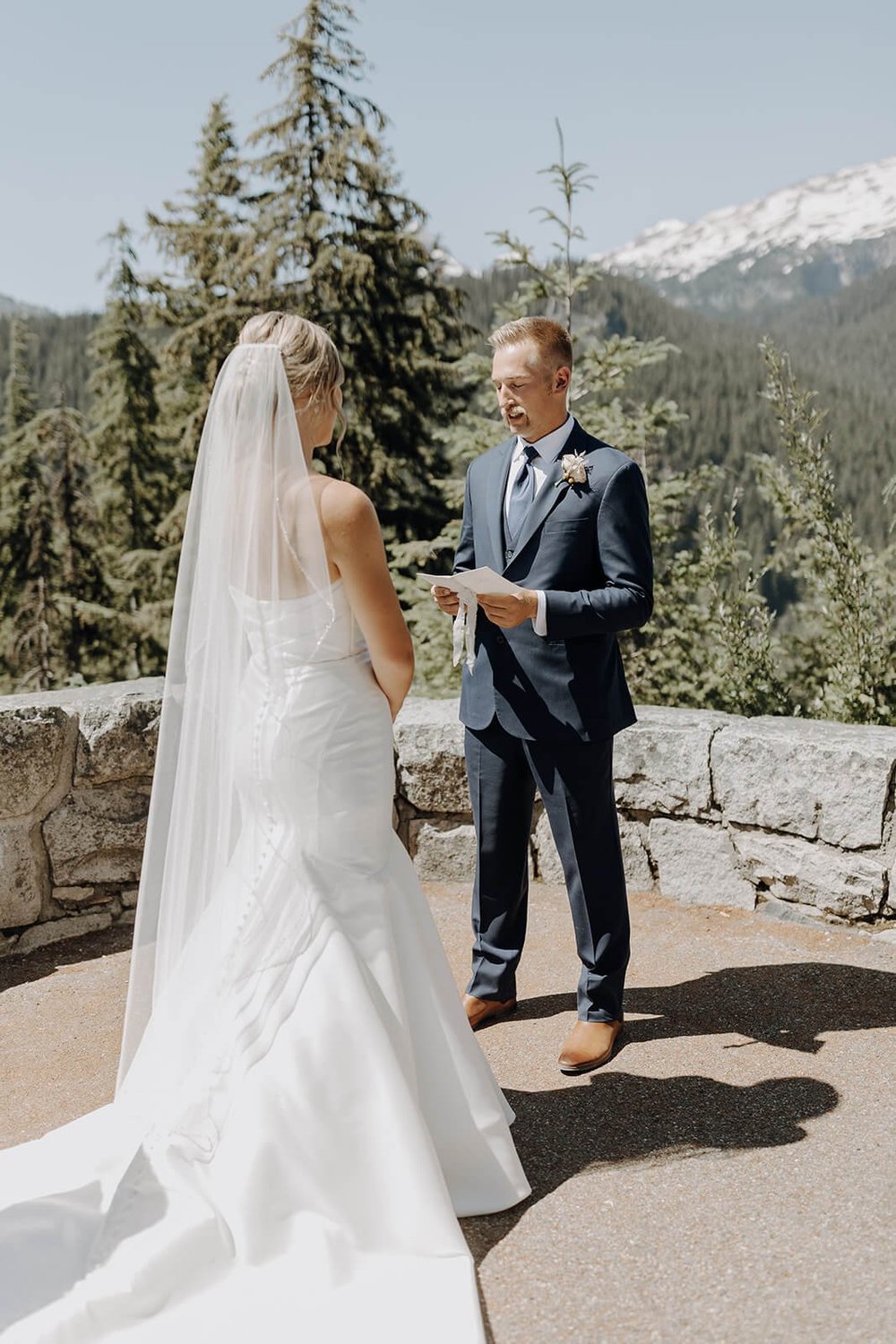 Groom reading vows to bride during outdoor wedding ceremony at Mount Rainier