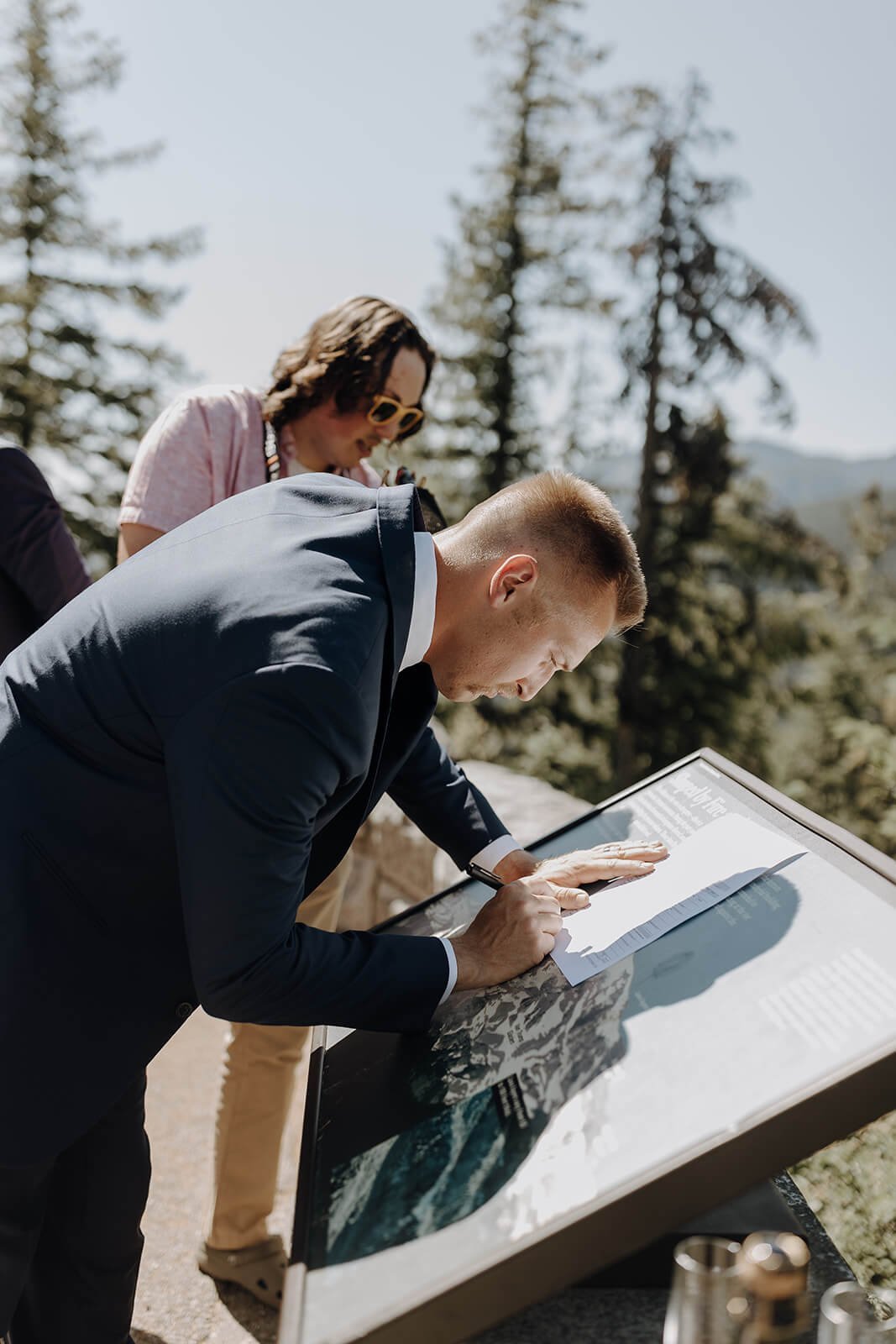 Groom signs Washington marriage license at Mount Rainier