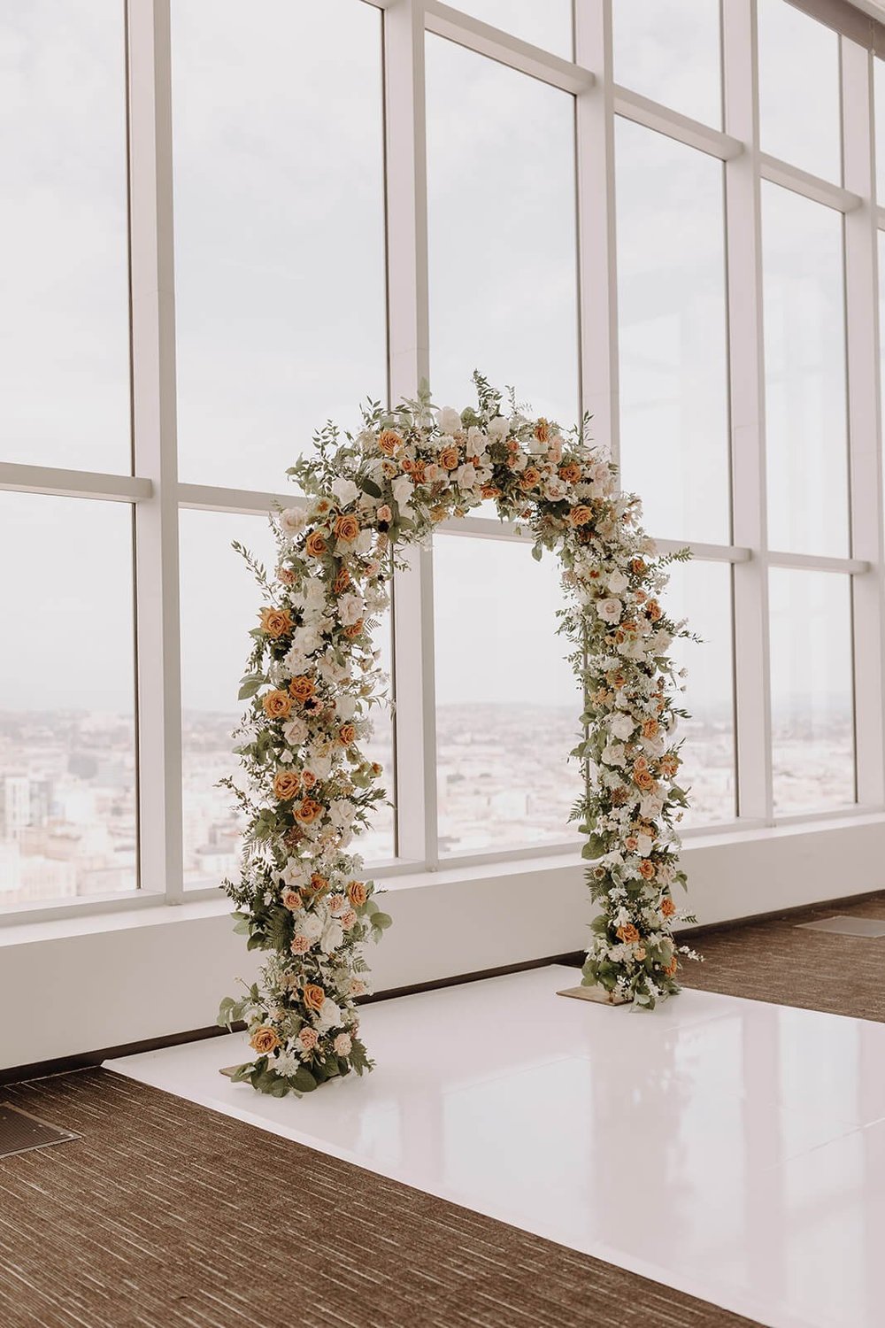 White, pink, orange, and green wedding floral arch