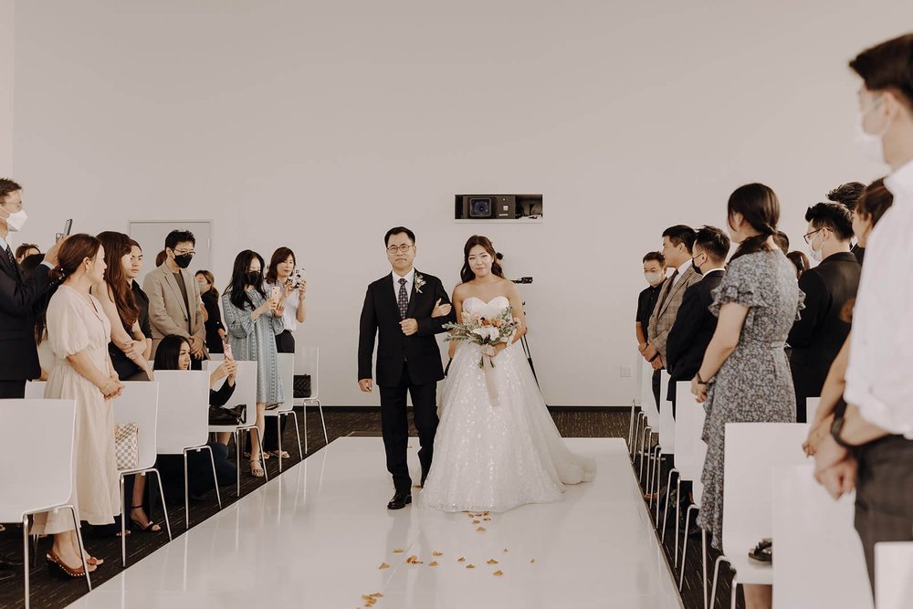 Bride and father walk down the aisle at city wedding in Los Angeles