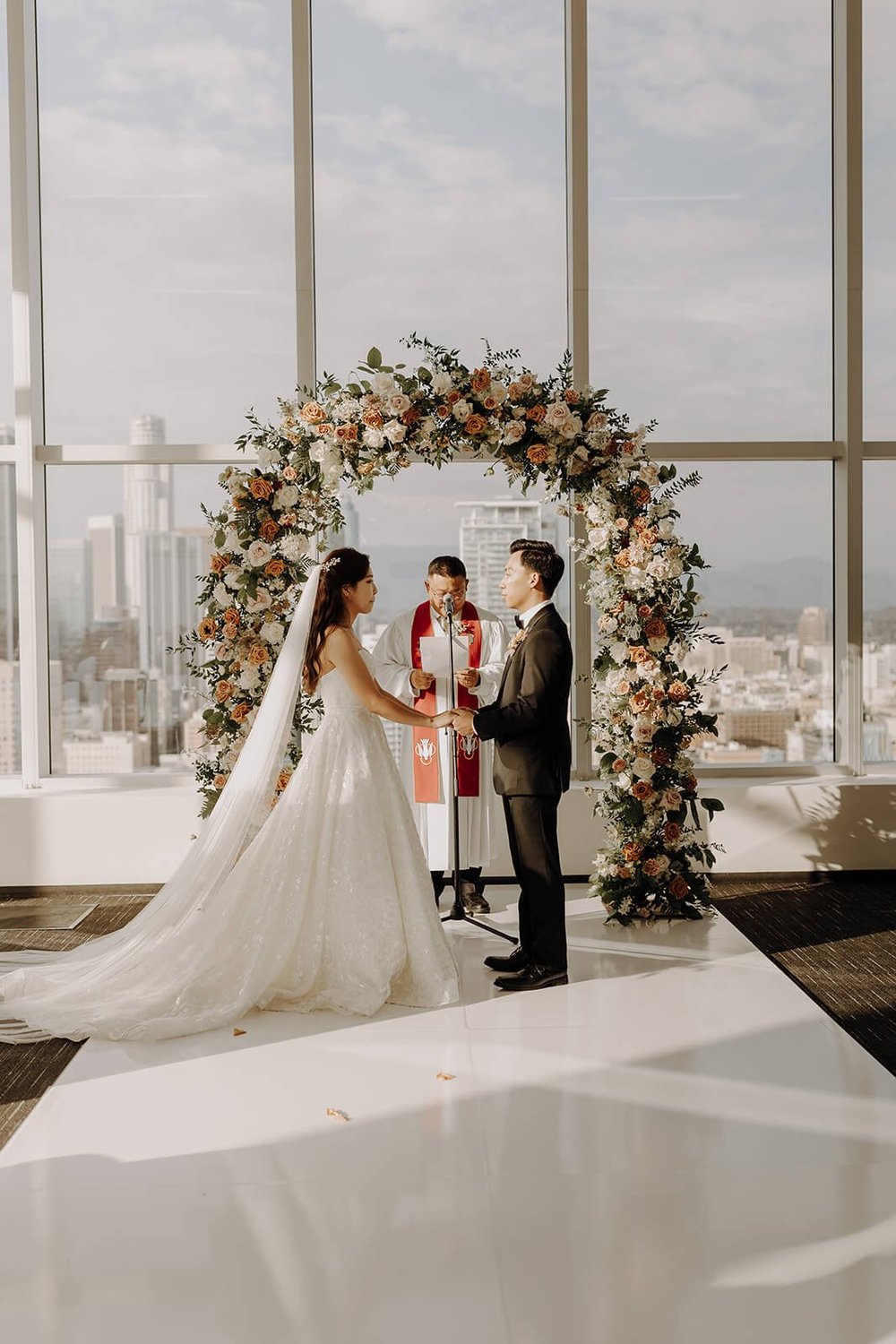 Bride and groom hold hands at city wedding in LA