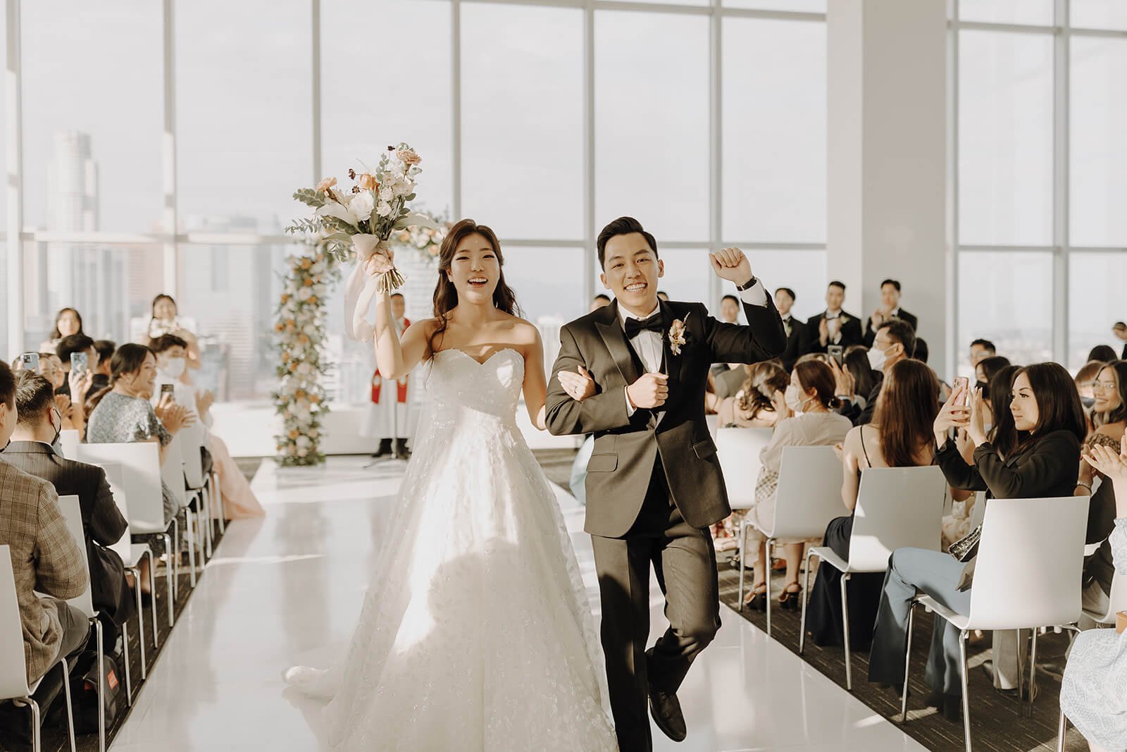 Bride and groom cheer while exiting the wedding ceremony