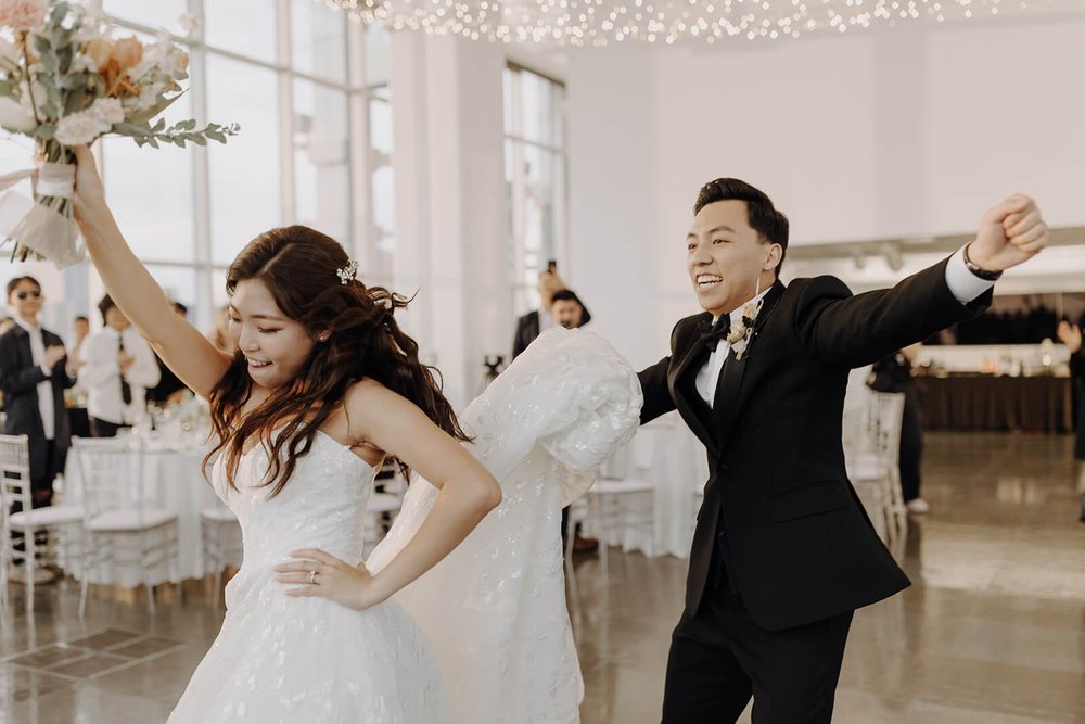 Bride and groom dancing while entering city wedding reception