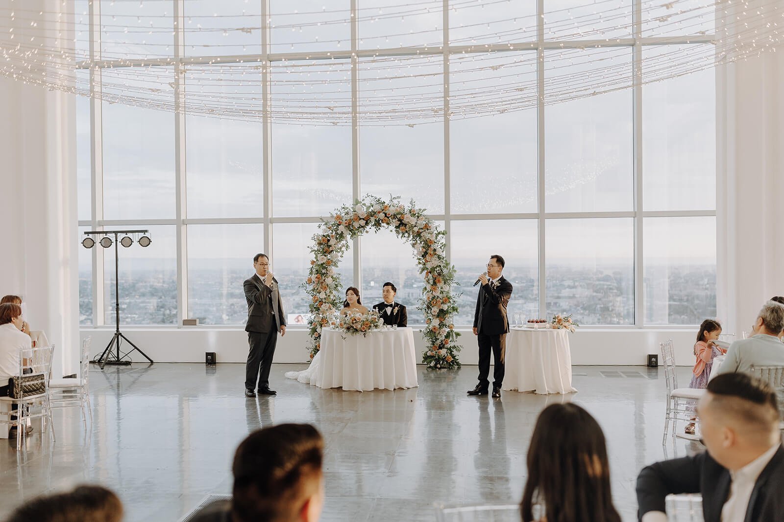Fathers sing to bride and groom during city wedding reception