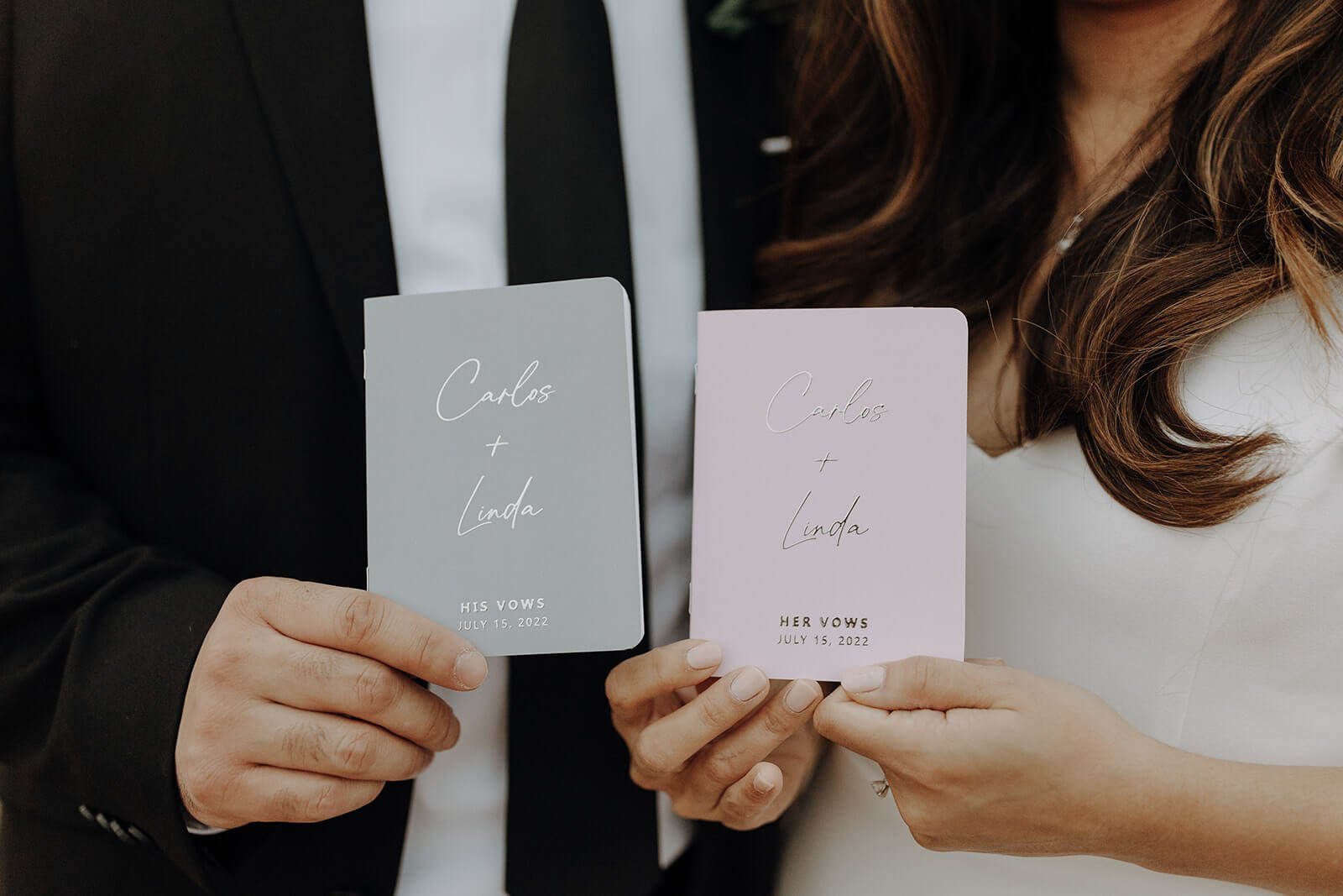 Bride and groom holding personalized vow books in the Arizona desert