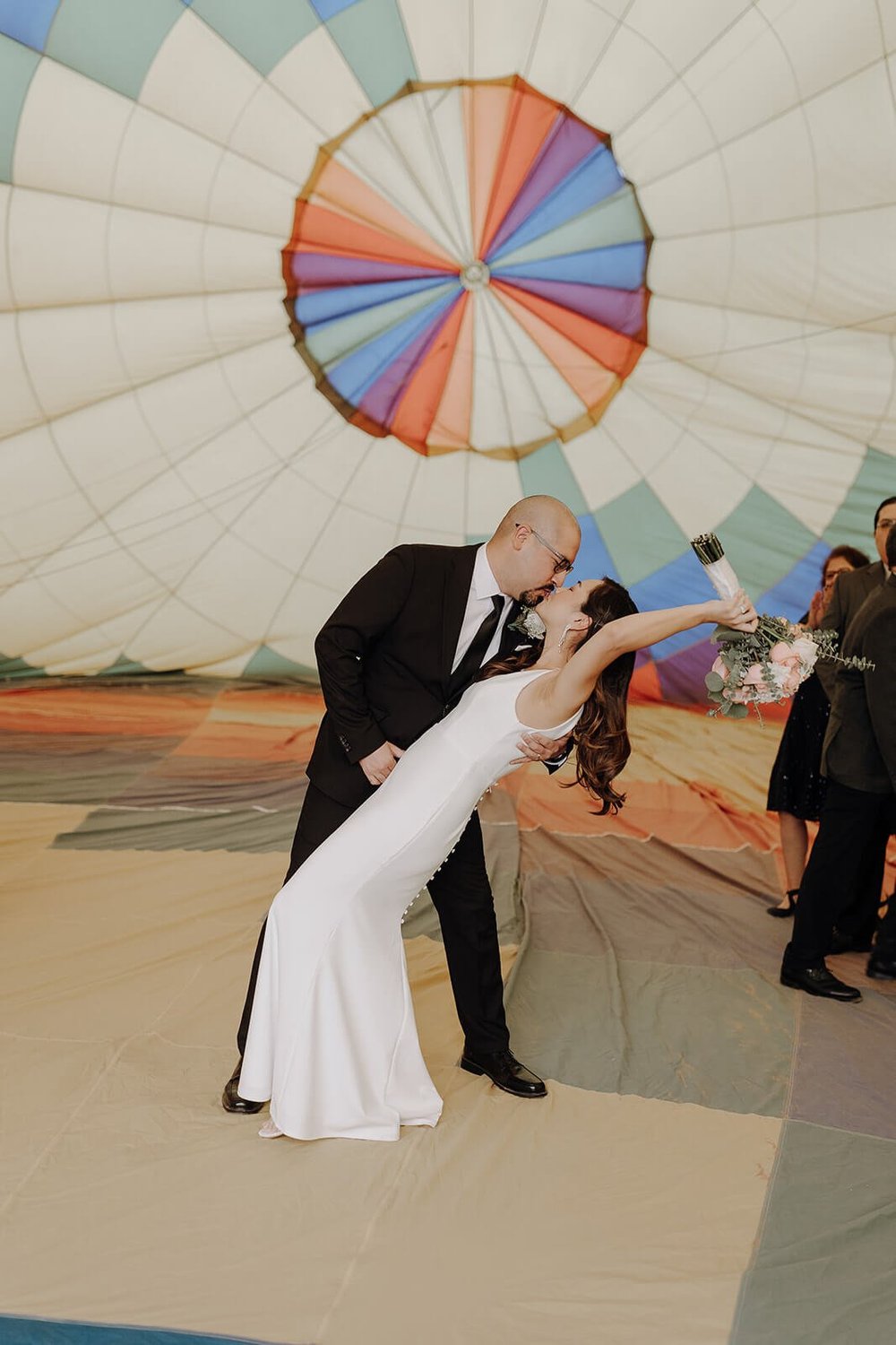 Bride and groom kiss inside a hot air balloon