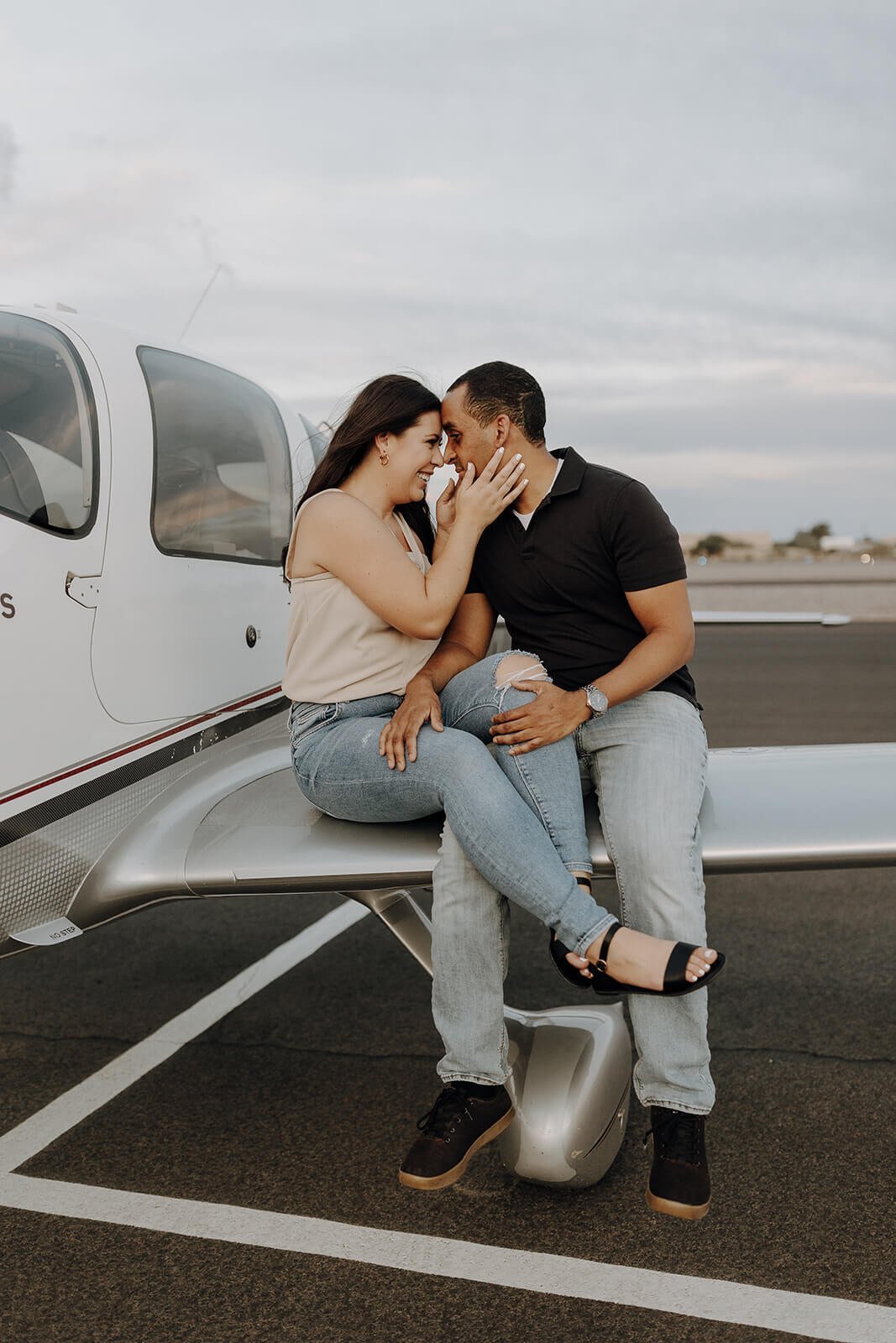 Couple sitting on the wing of the plane for unique engagement photos