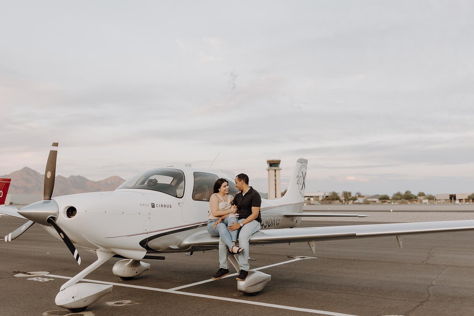 Couple sitting on the wing of the plane at Scottsdale airport