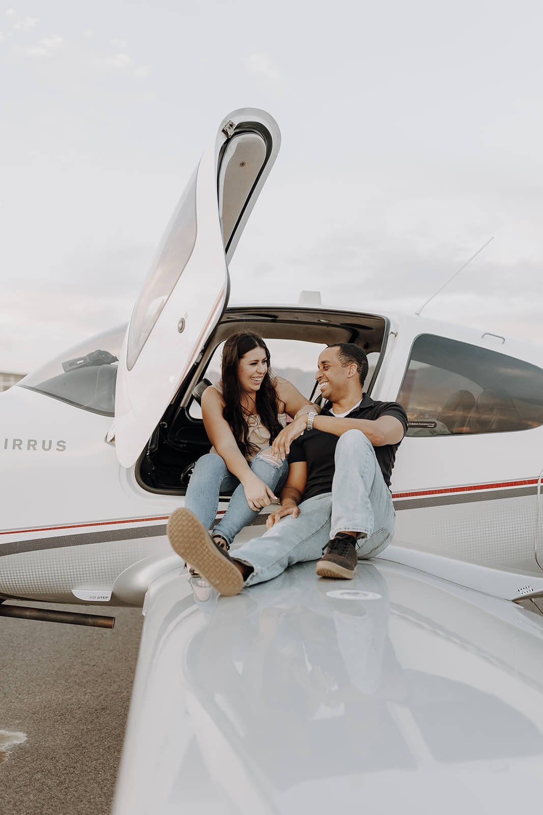 Couple sitting on the wing of the plane at Scottsdale airport
