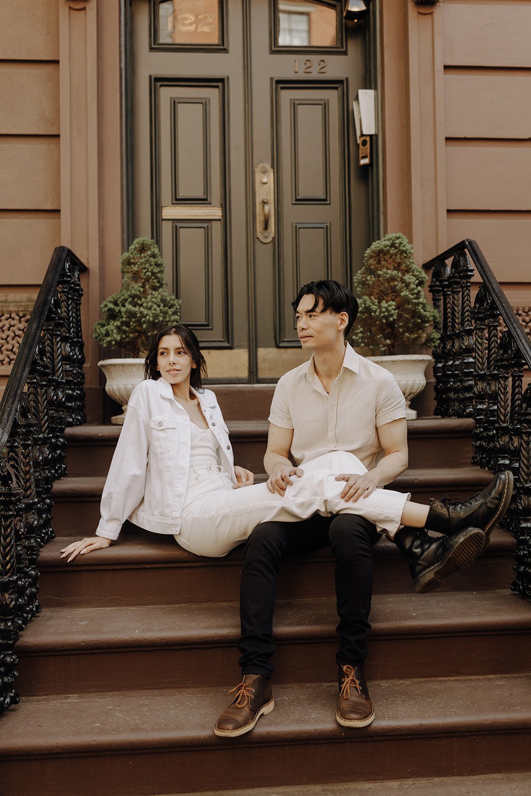 Couple sitting on the stoop during New York Engagement Photos in Manhattan