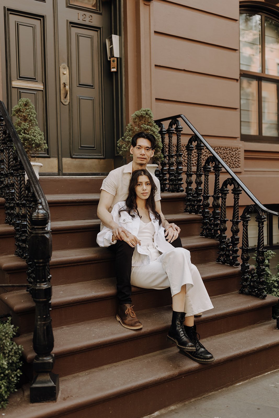 Couple sitting on the stoop during New York Engagement Photos in Manhattan