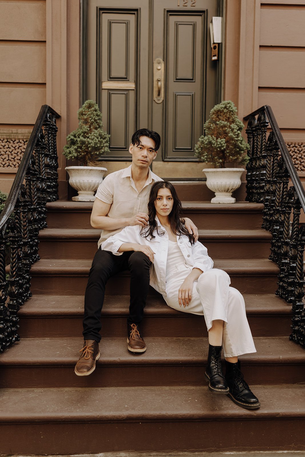 Couple sitting on the stoop during NYC Engagement Photos in Manhattan