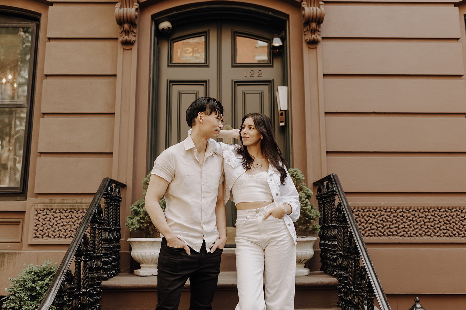 Couple posing in front of a stoop during NYC Engagement Photos in Manhattan