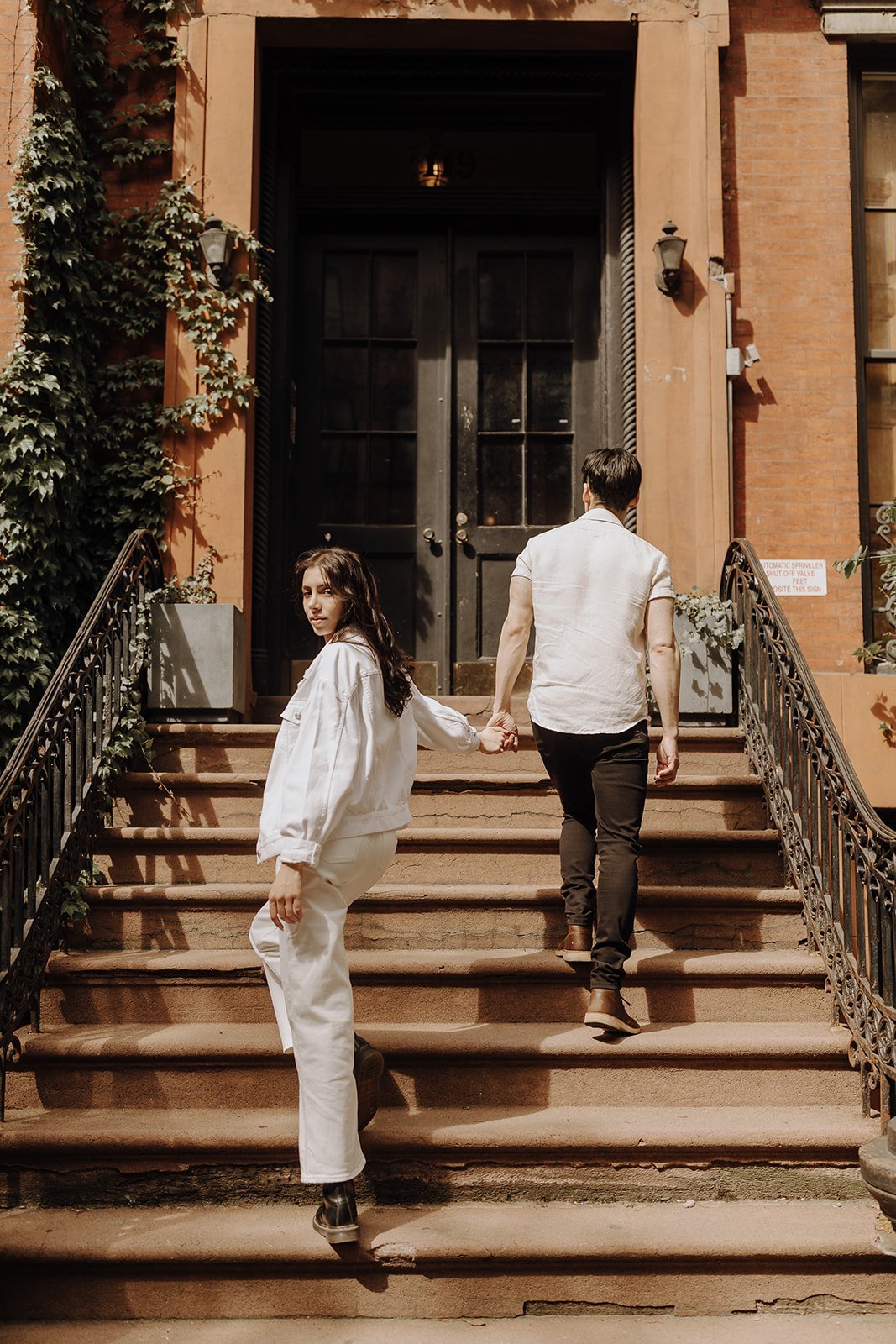 Couple standing on the stoop during New York engagement photos